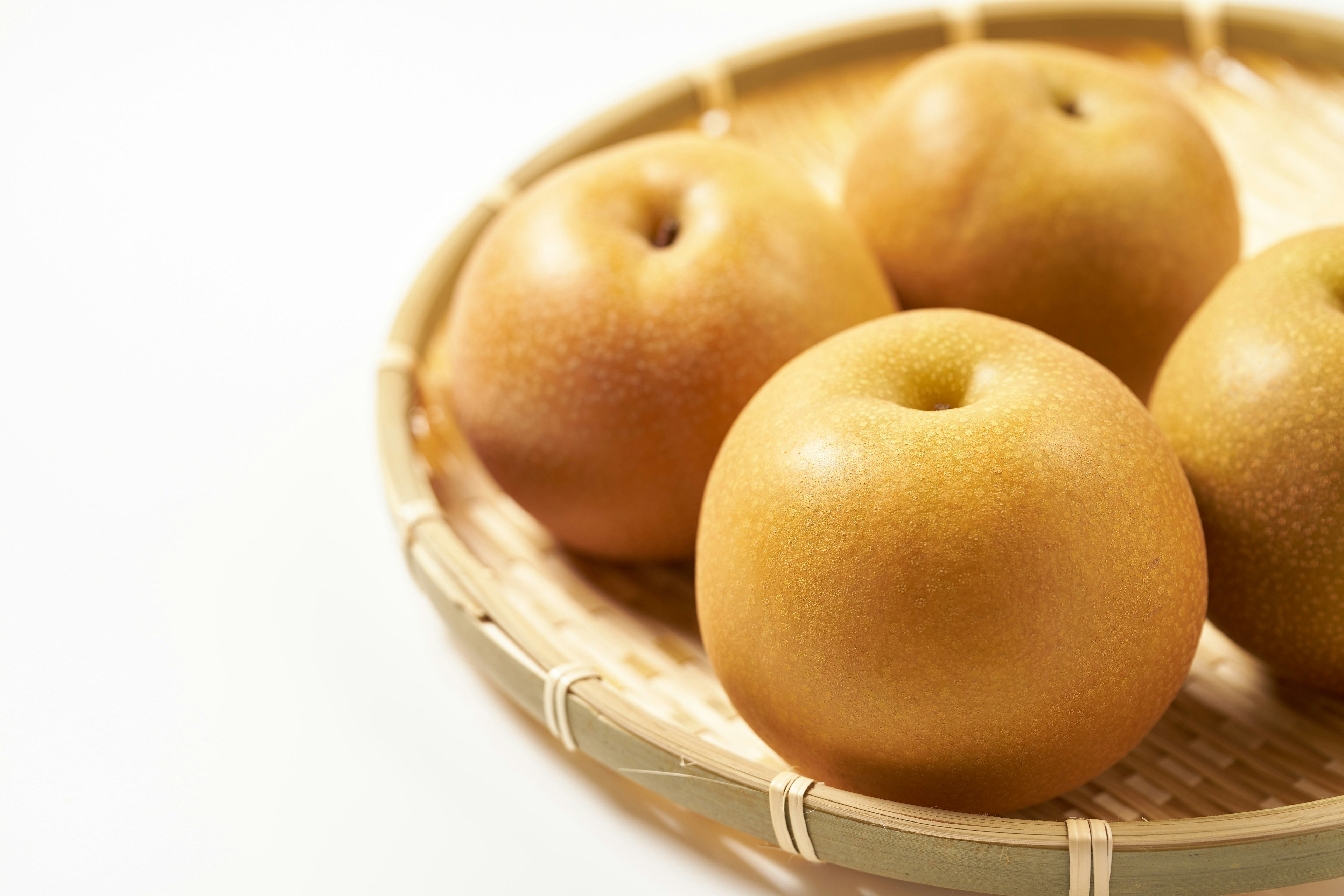 A basket containing several golden pears arranged neatly