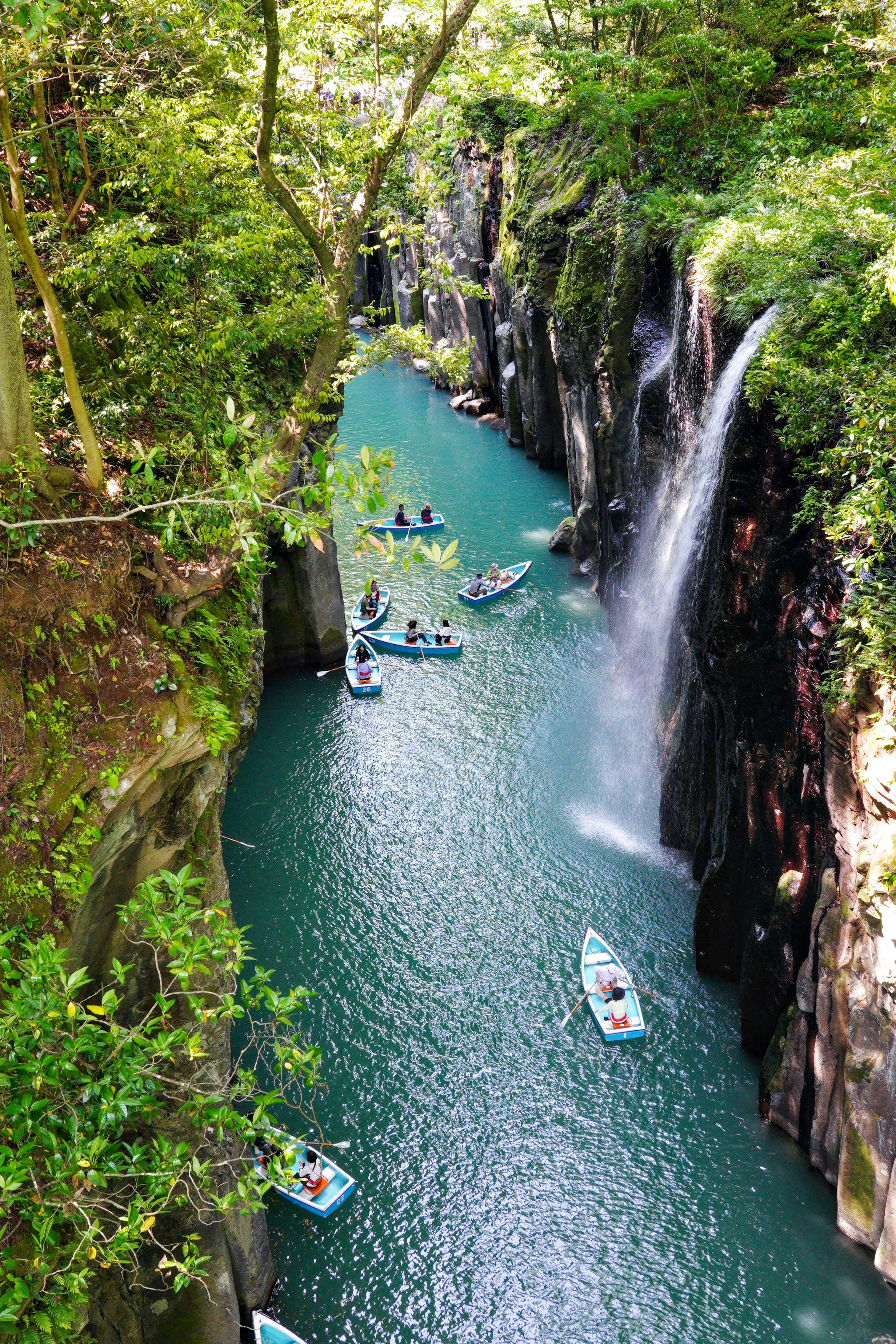 Lembah indah dengan air biru dan air terjun perahu kecil mengapung