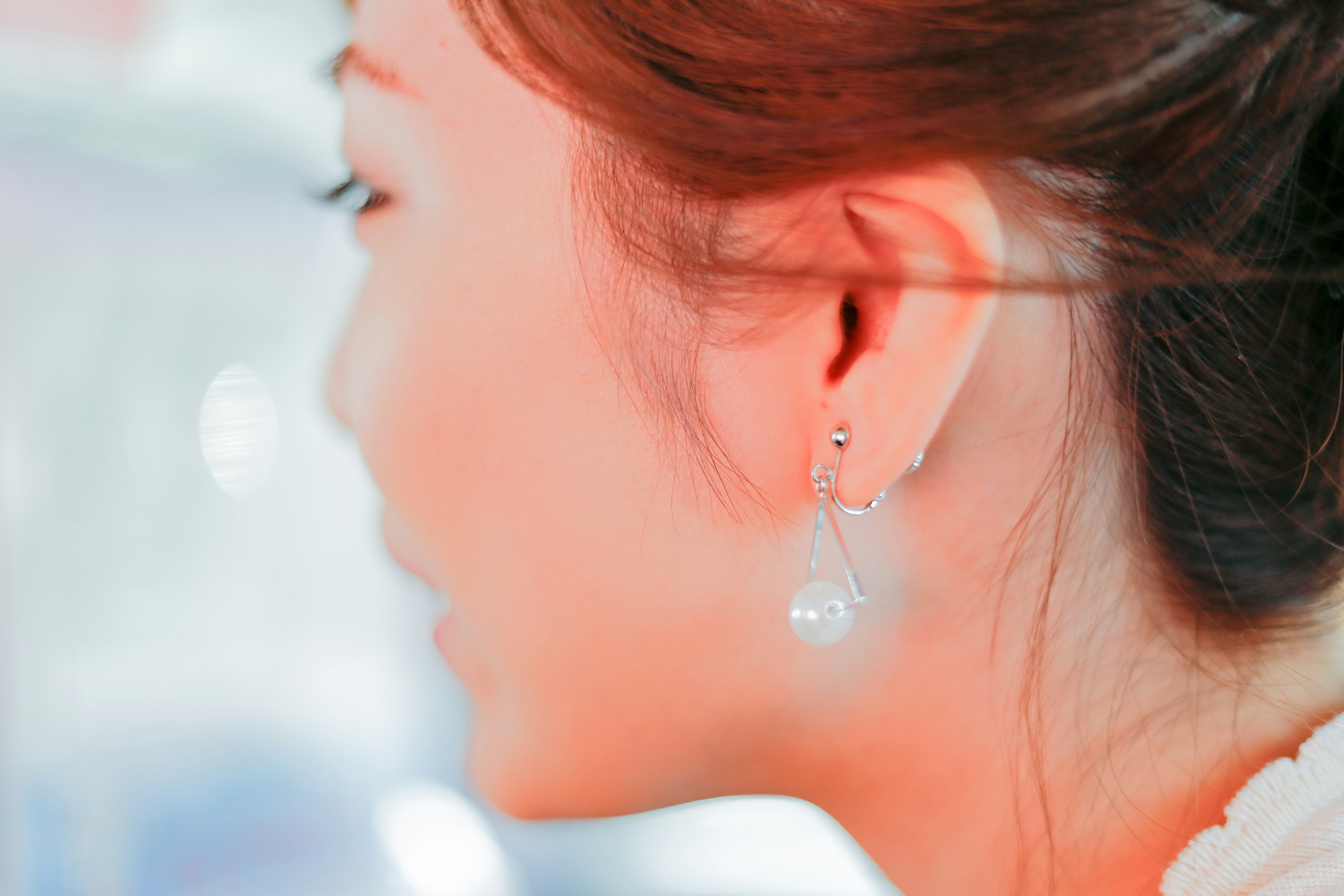 Vue de profil d'une femme portant une boucle d'oreille en perles