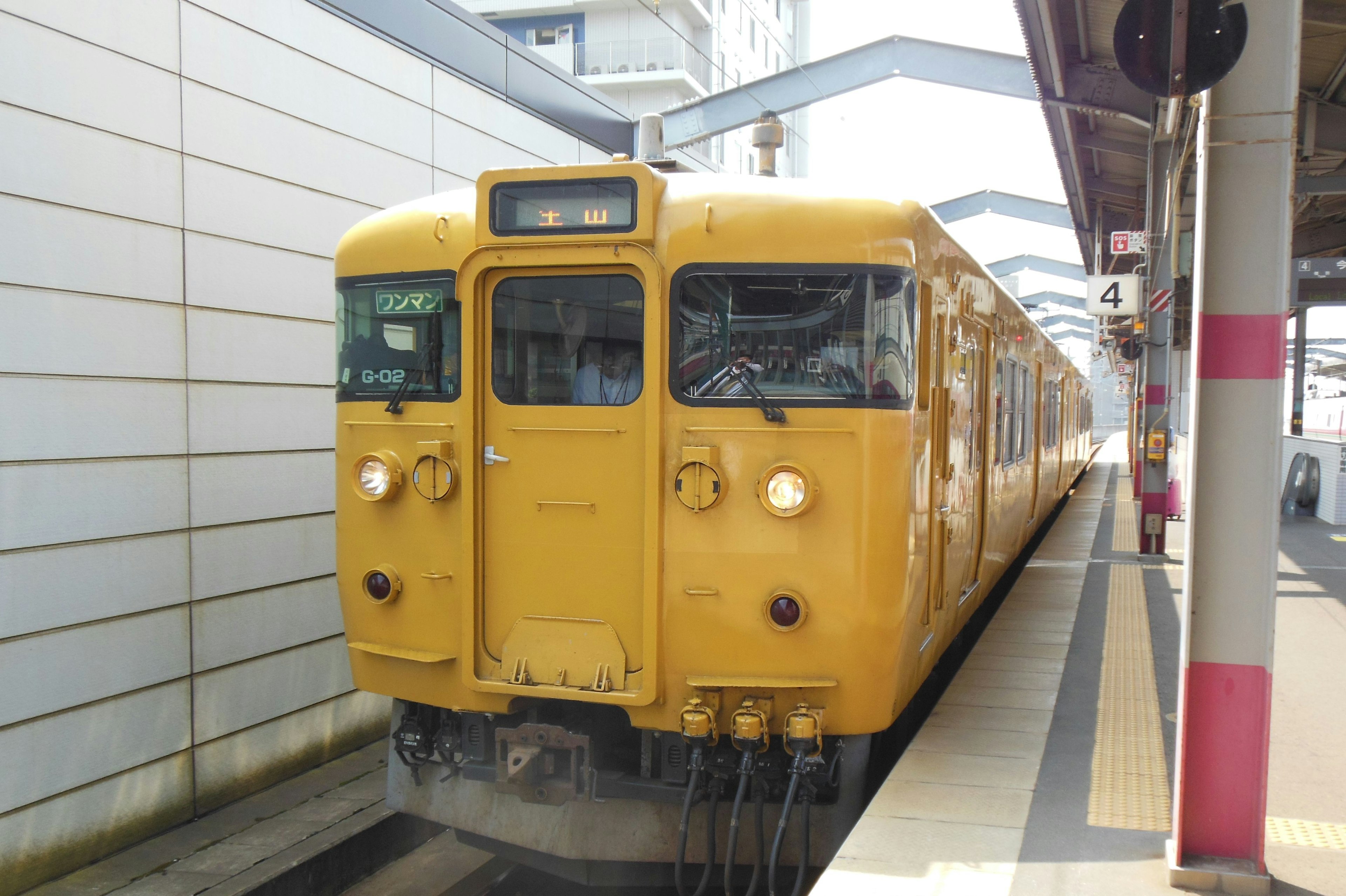 Kereta kuning yang berhenti di stasiun