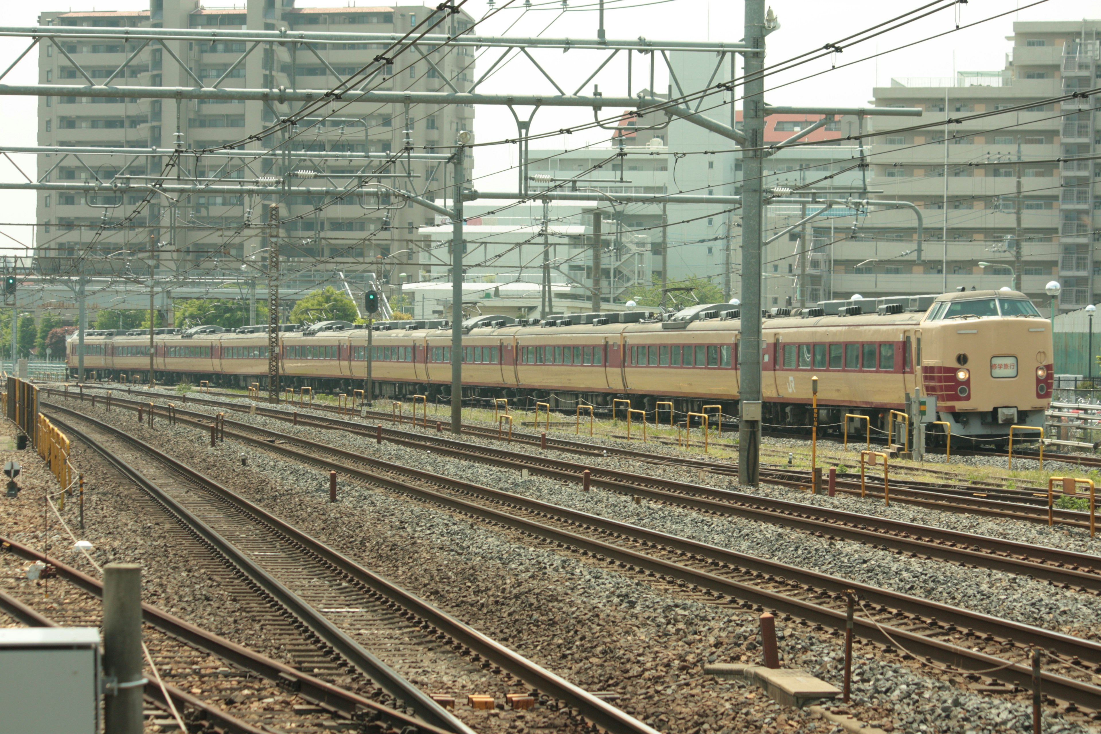 Train arrêté à une gare avec des bâtiments environnants