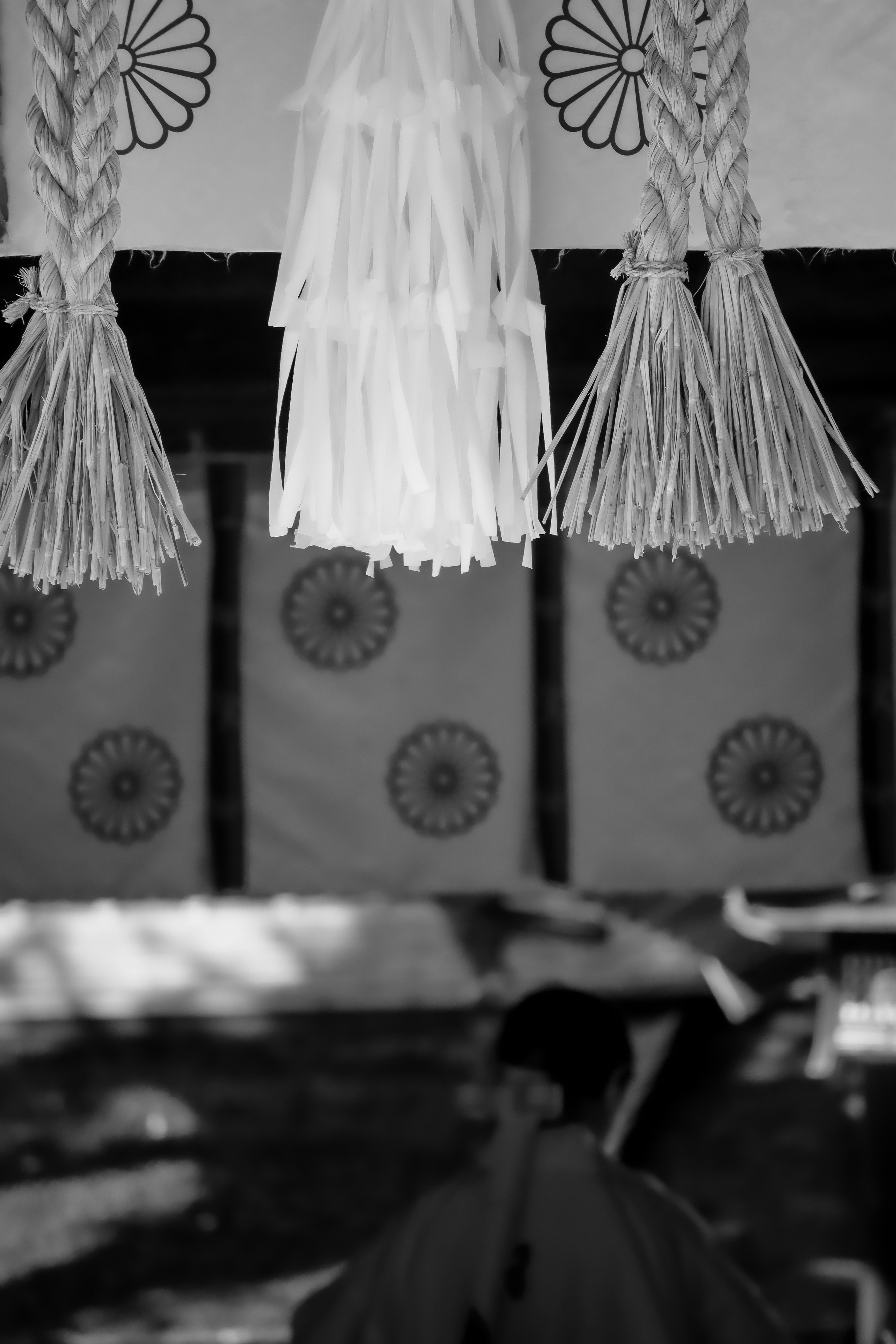 Black and white image featuring traditional decorations and patterned fabric hanging