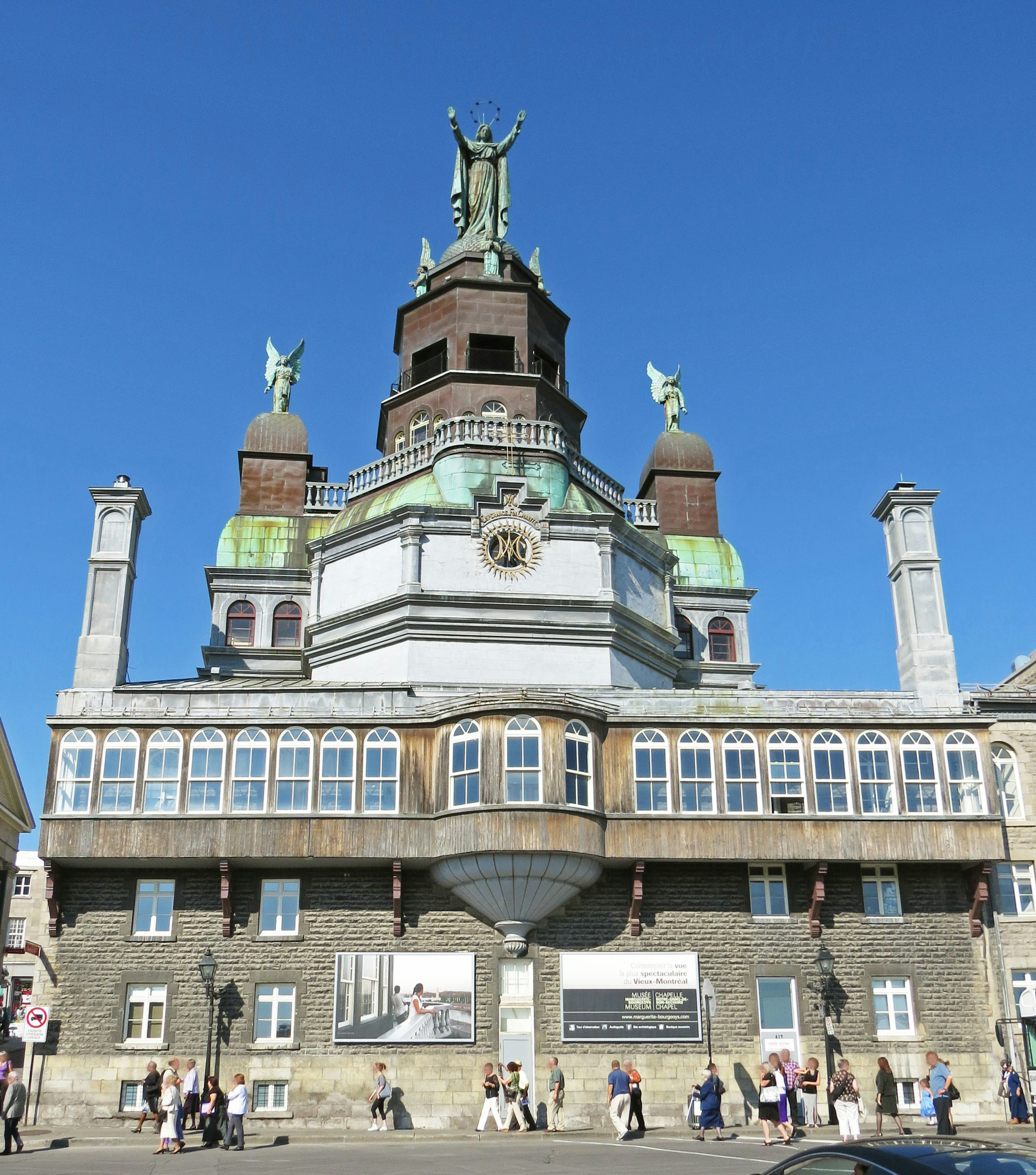 Hermoso edificio histórico bajo un cielo azul con personas caminando