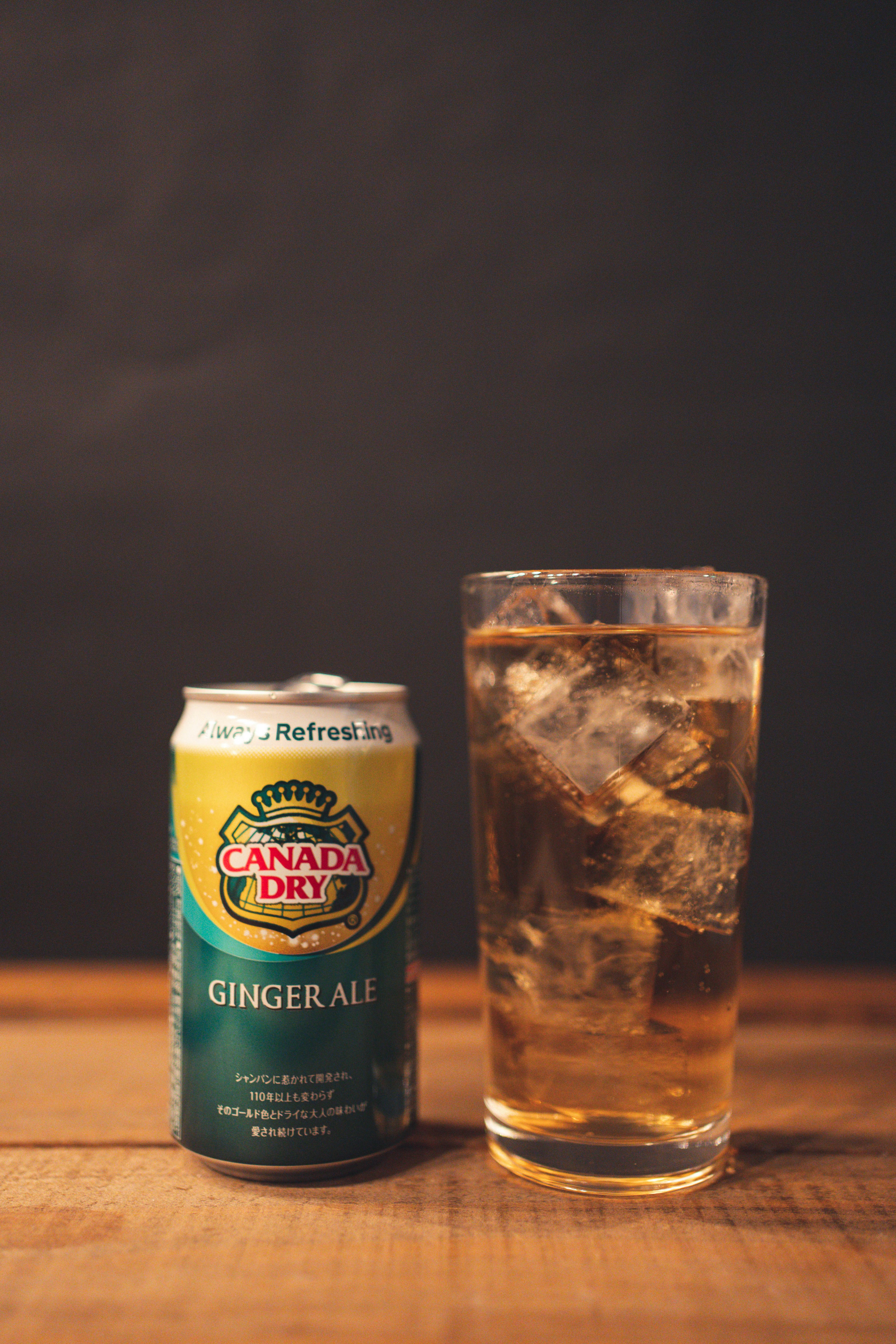 Kota ginger ale Canada Dry di samping gelas berisi es dan minuman