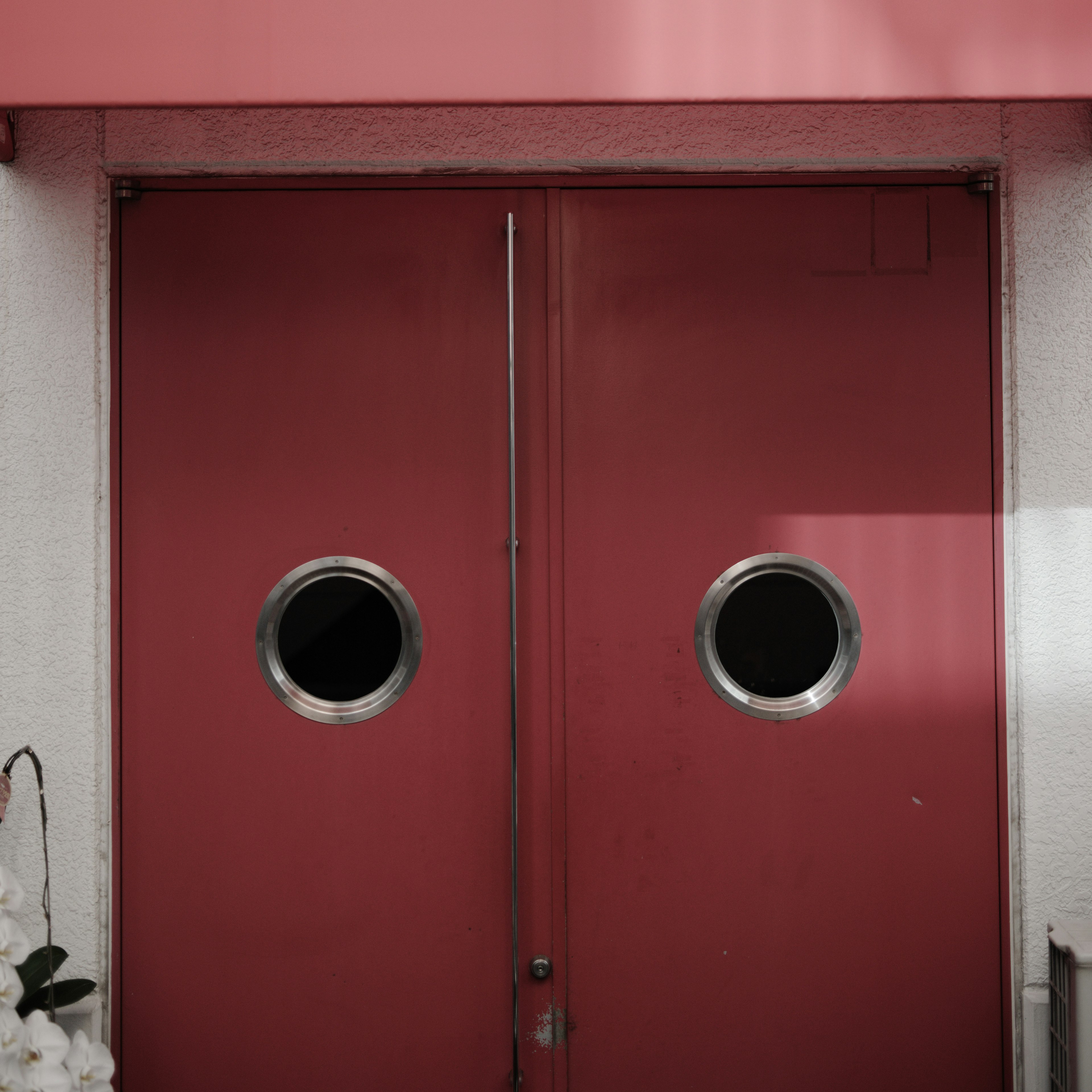 Pintu ganda merah dengan jendela bulat