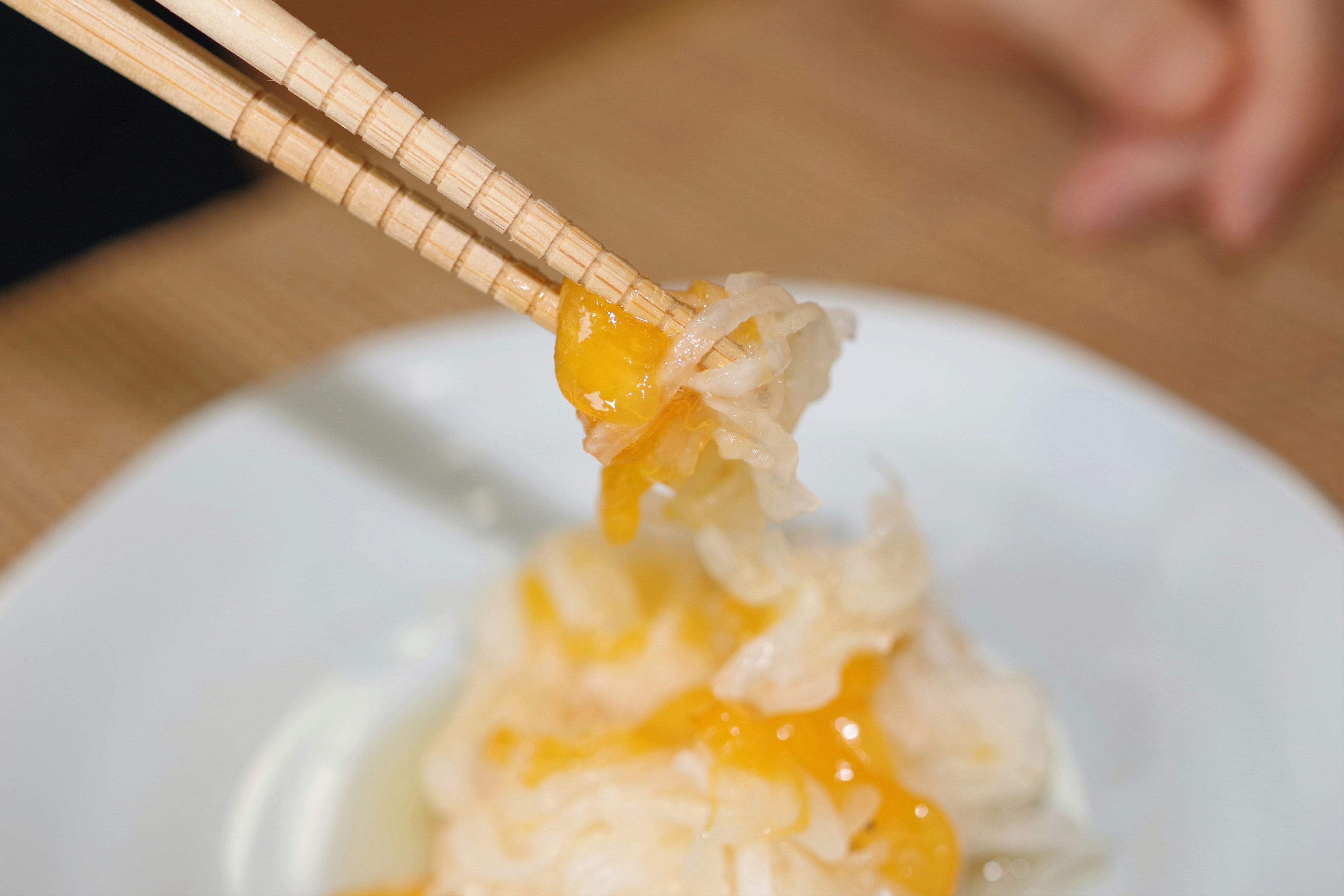 用筷子夾起的菜餚，展示蛋黃和蛋白