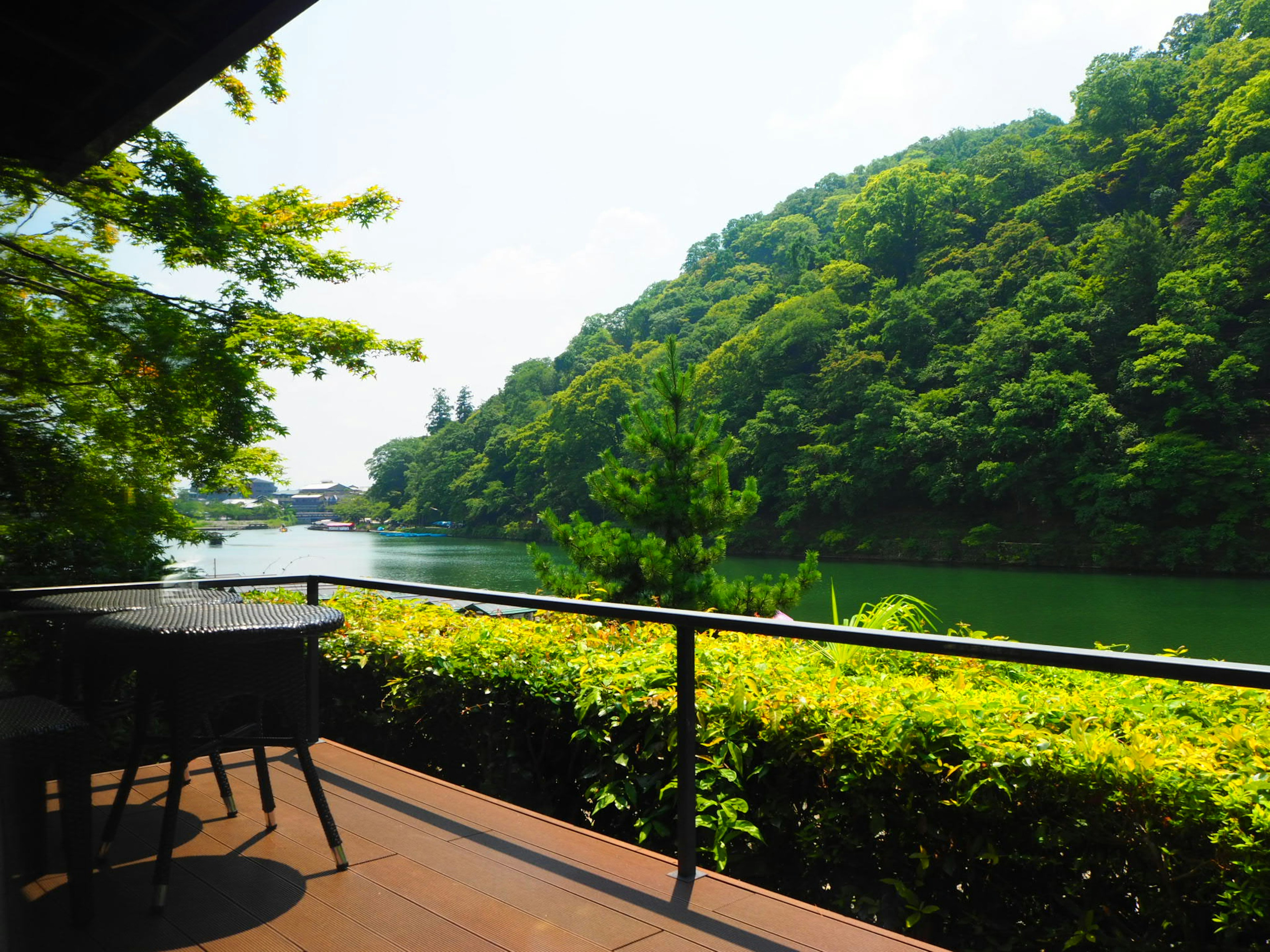 Scenic view from a terrace overlooking lush green hills and a tranquil lake