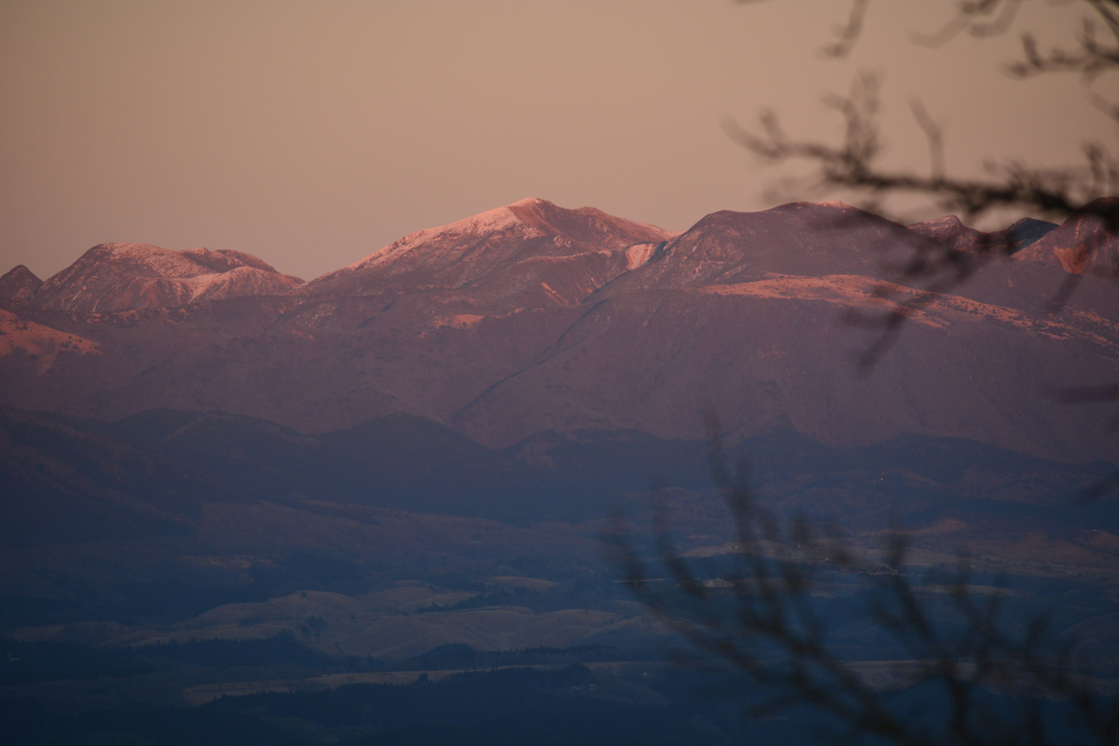 夕暮れ時の山々の景色 薄紫色の空に照らされた雪をかぶった峰