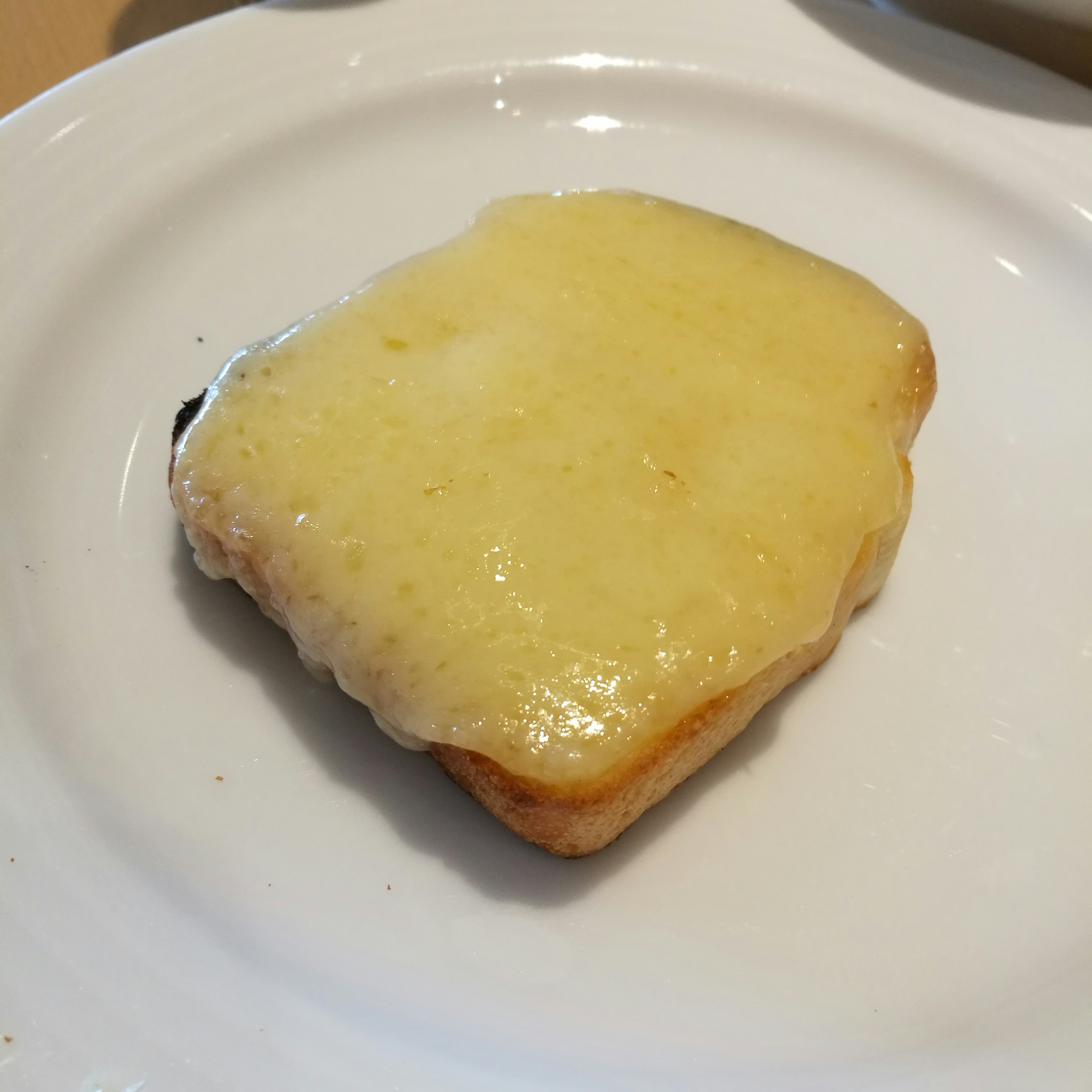 Toast con formaggio fuso su un piatto bianco