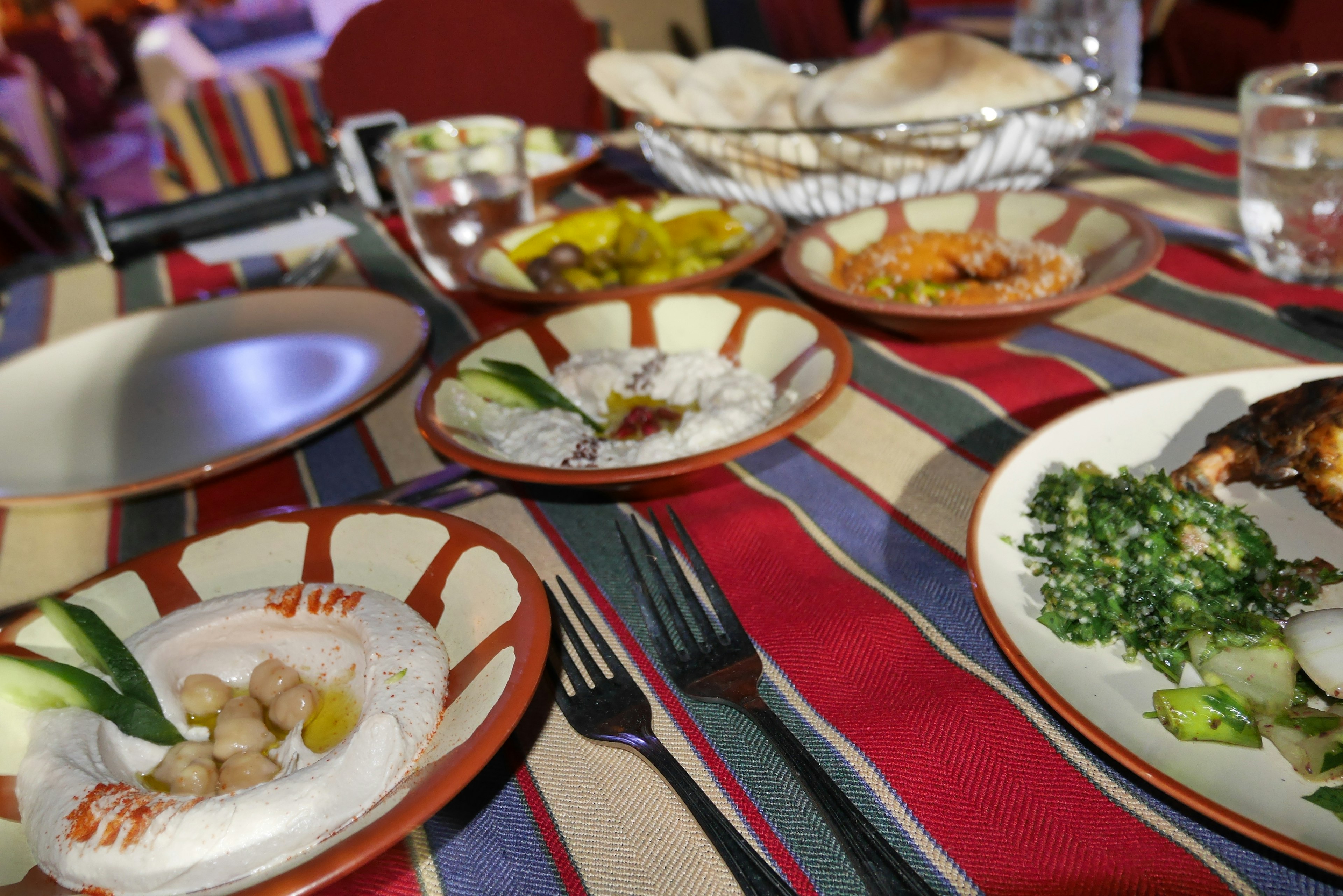 A table set with colorful dishes featuring rice and vegetables on patterned plates