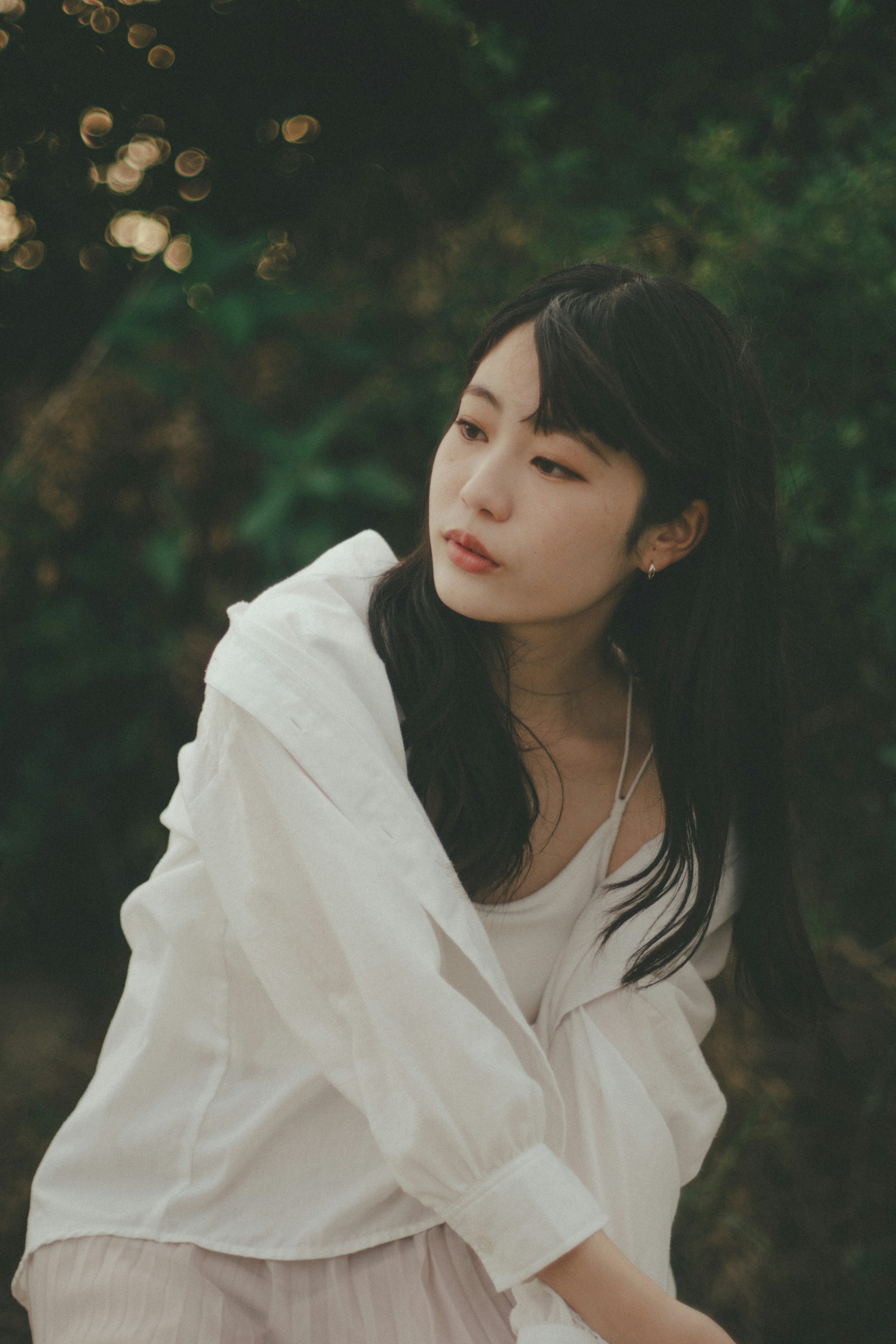 Une femme en chemise blanche contemplant dans la nature