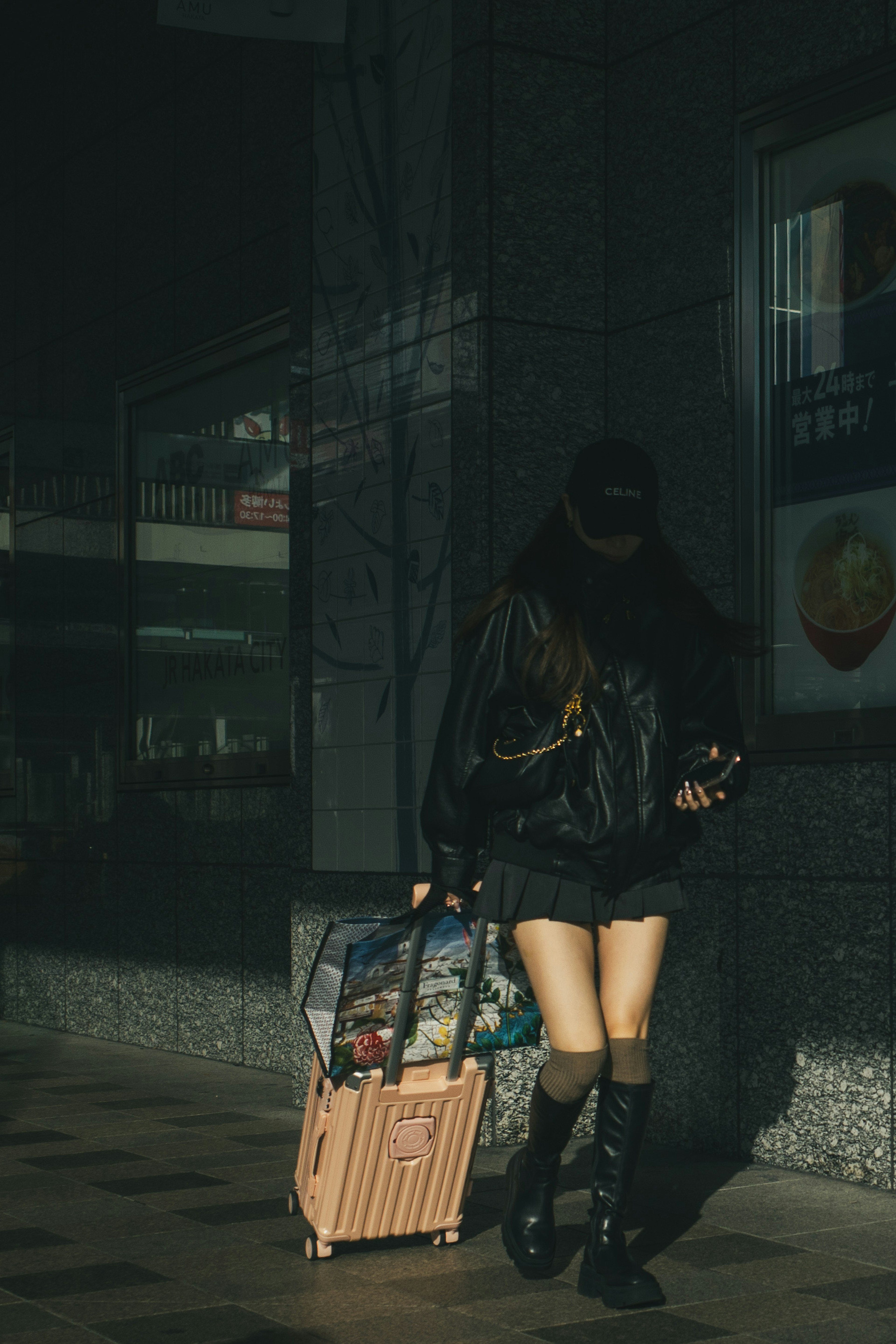 Una mujer caminando con una maleta en un fondo poco iluminado