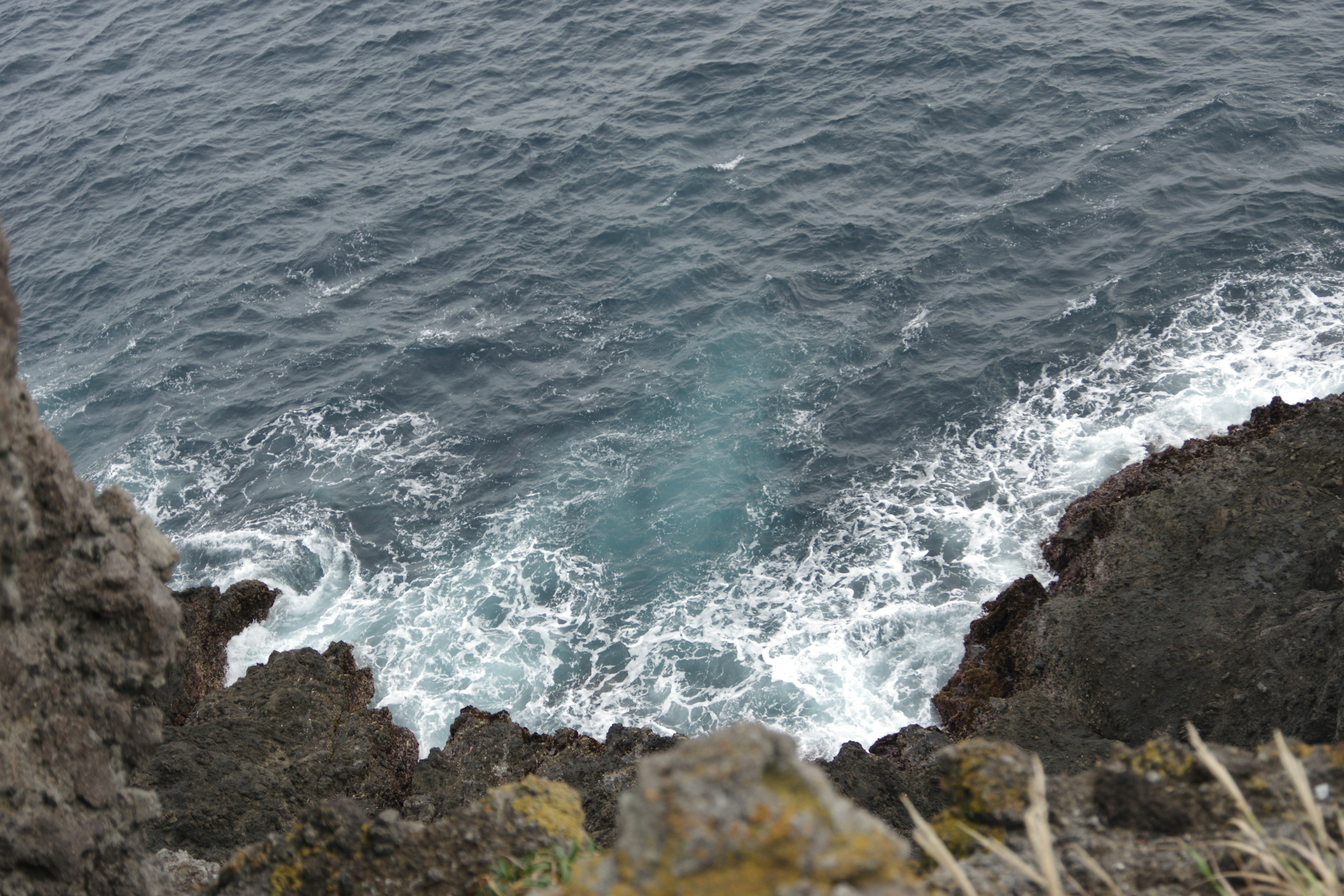 Vista delle onde oceaniche che si infrangono contro scogliere rocciose