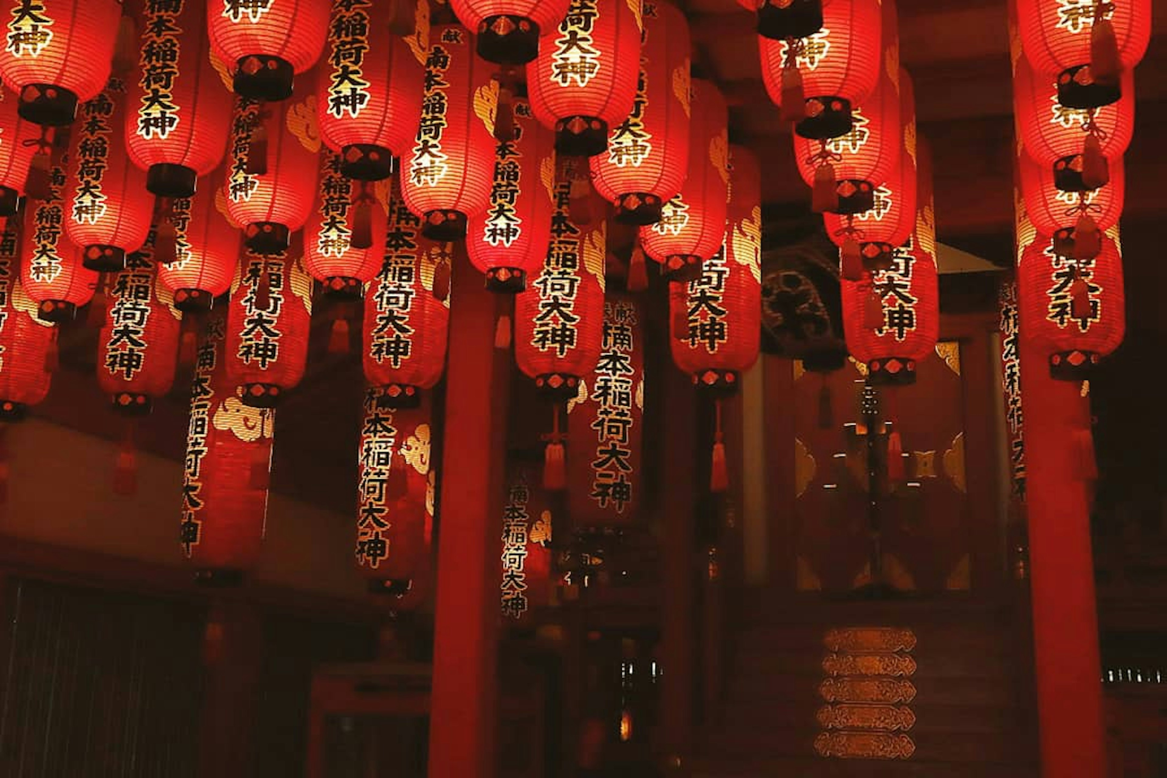 赤い提灯が吊るされた伝統的な日本の神社の内部