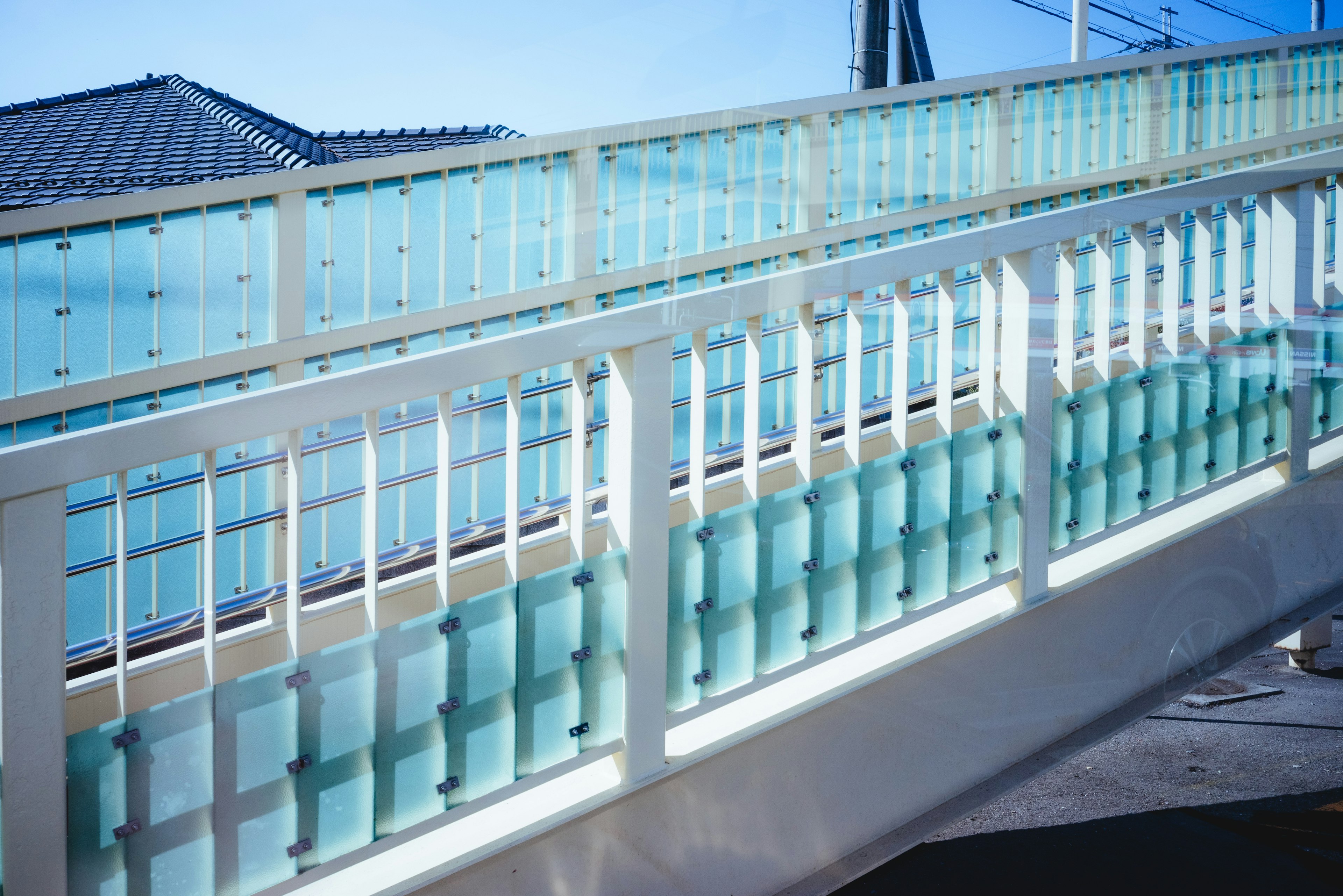 Close-up of a bridge featuring blue glass railings