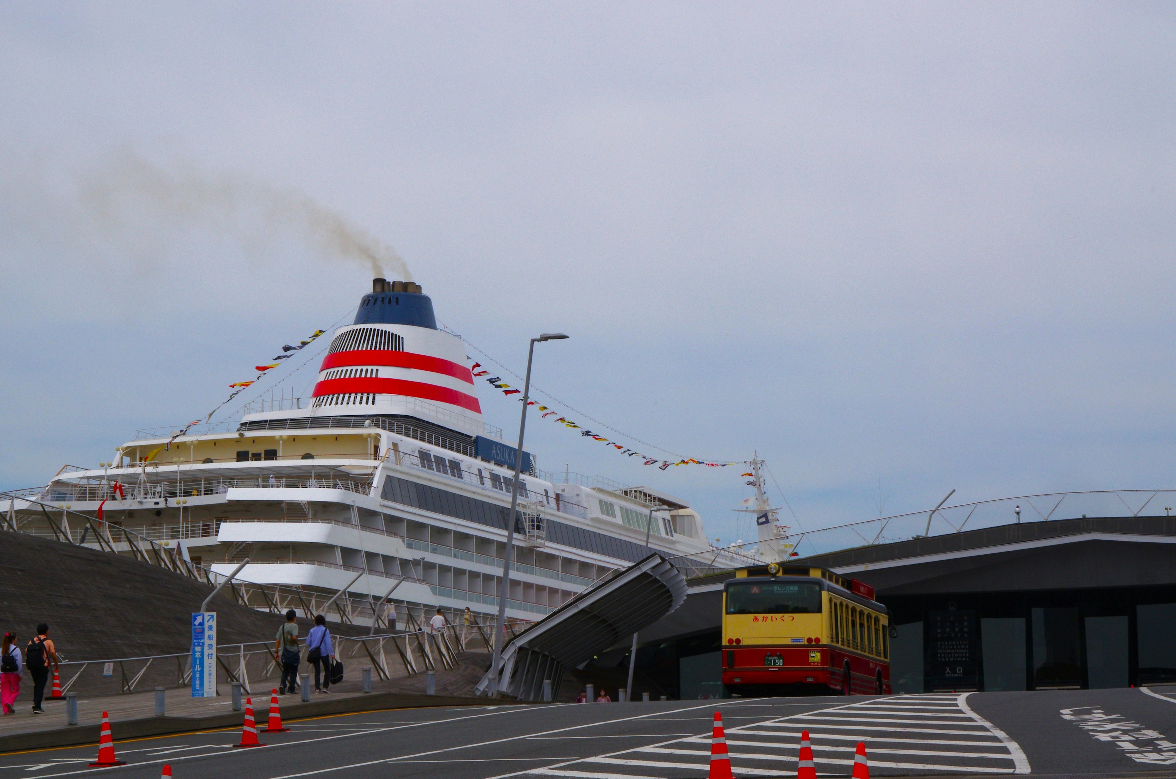 Grand bateau de croisière amarré au port avec un bus à proximité