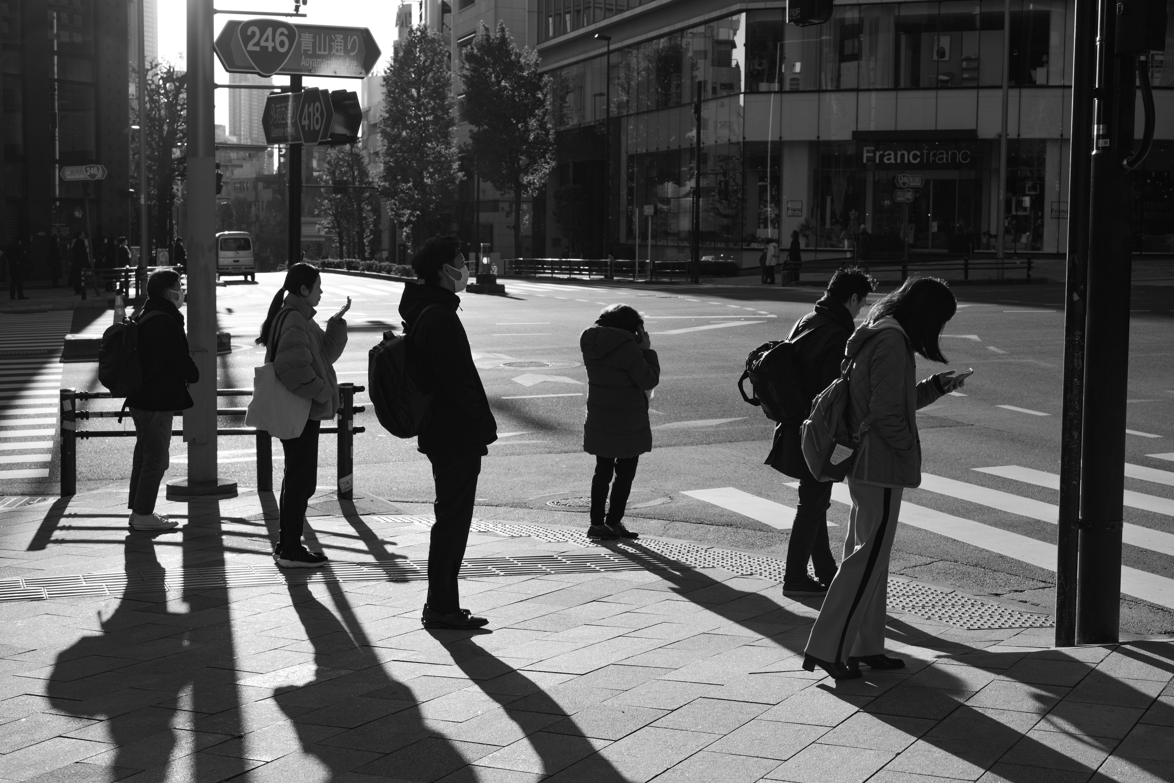 Personas esperando en un semáforo en una escena urbana en blanco y negro