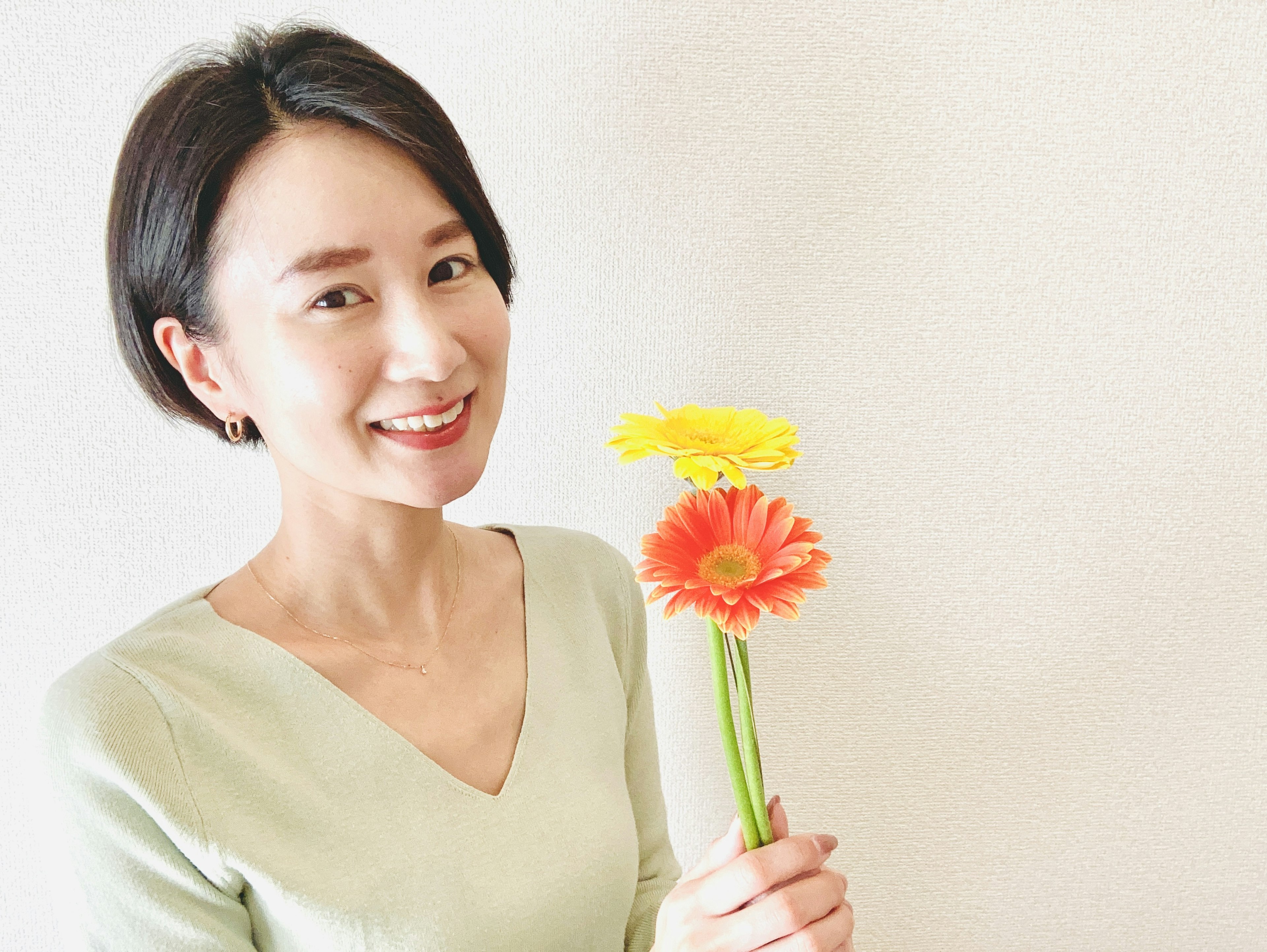 Una mujer sonriente sosteniendo flores coloridas