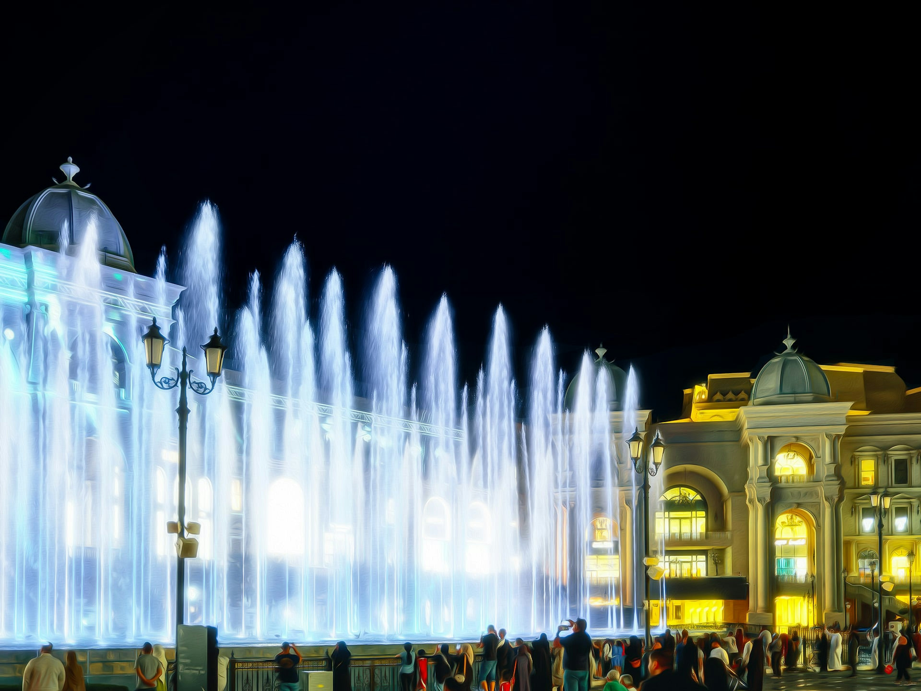 Spectacle de fontaine nocturne vibrant avec des bâtiments illuminés