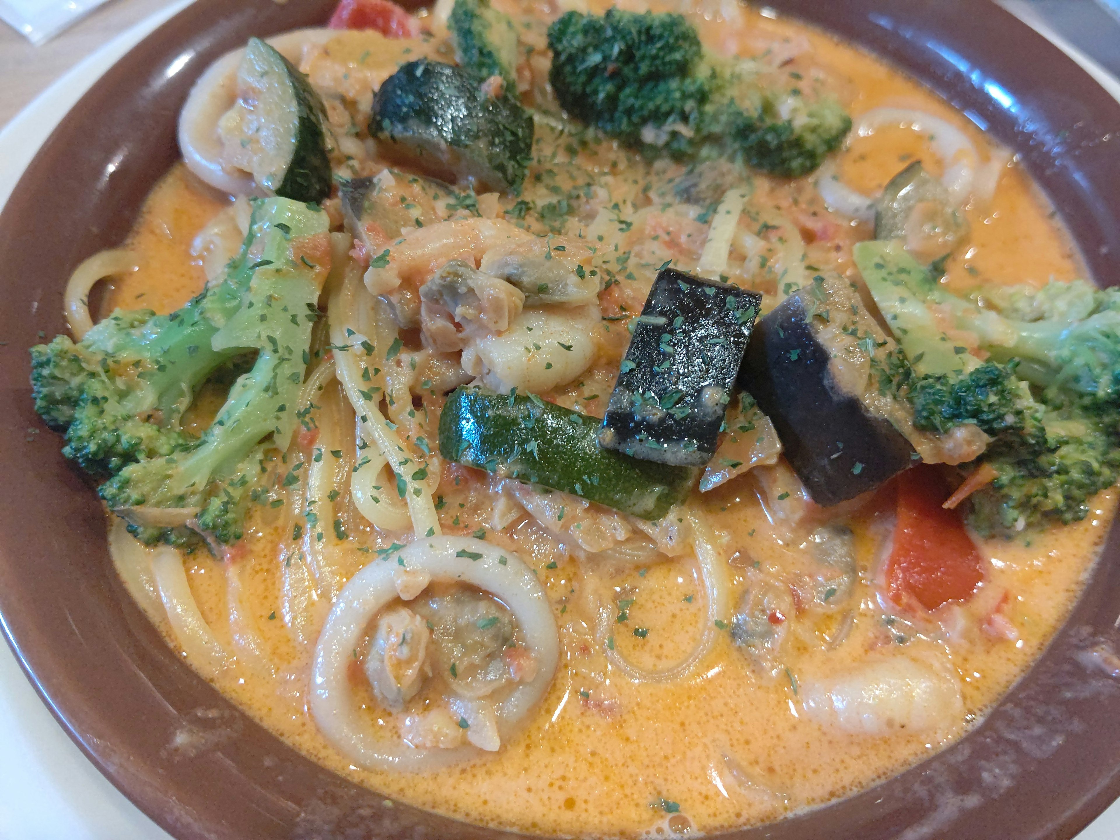 Creamy pasta dish with vegetables and seafood