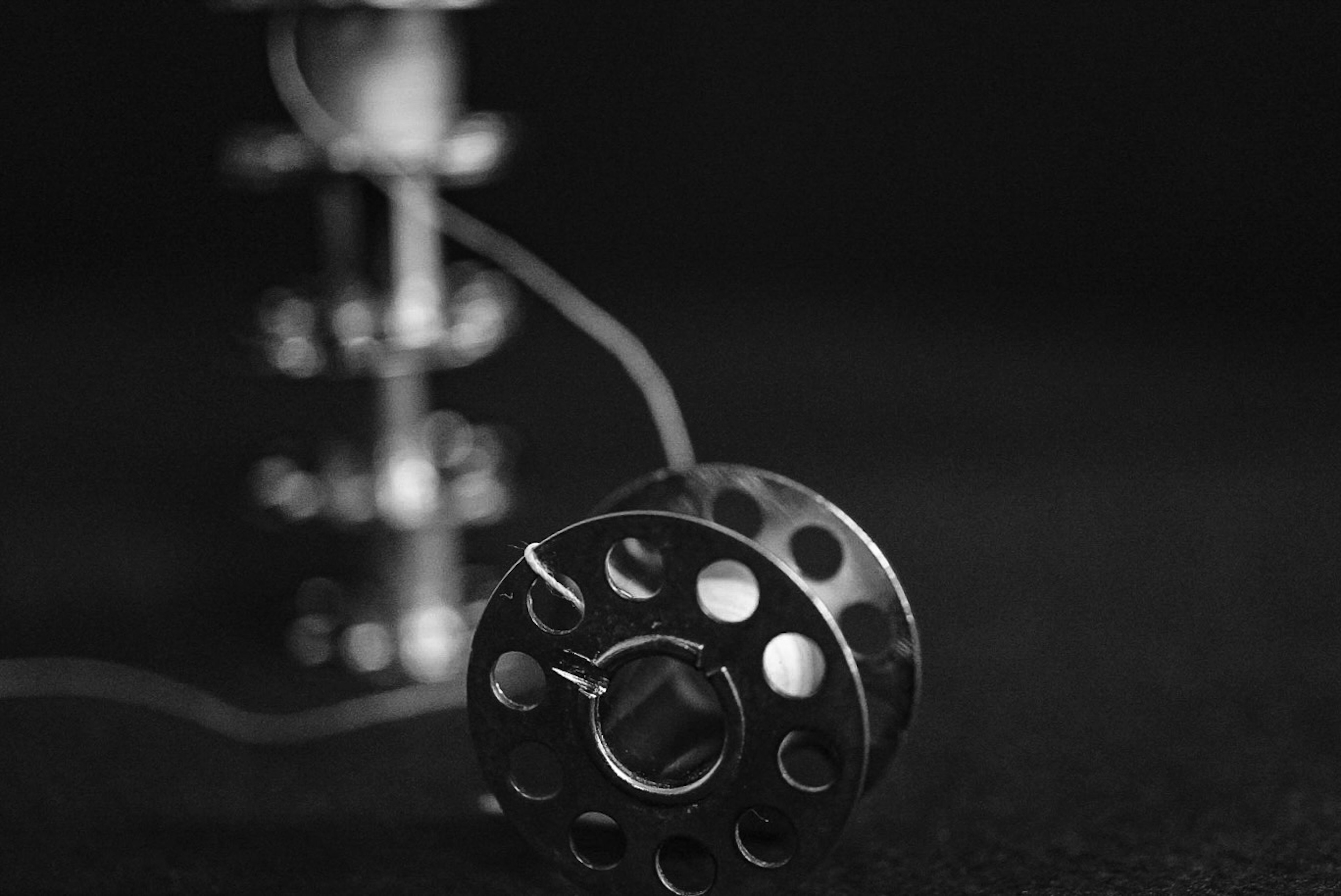 Metal spool and cable on a black background