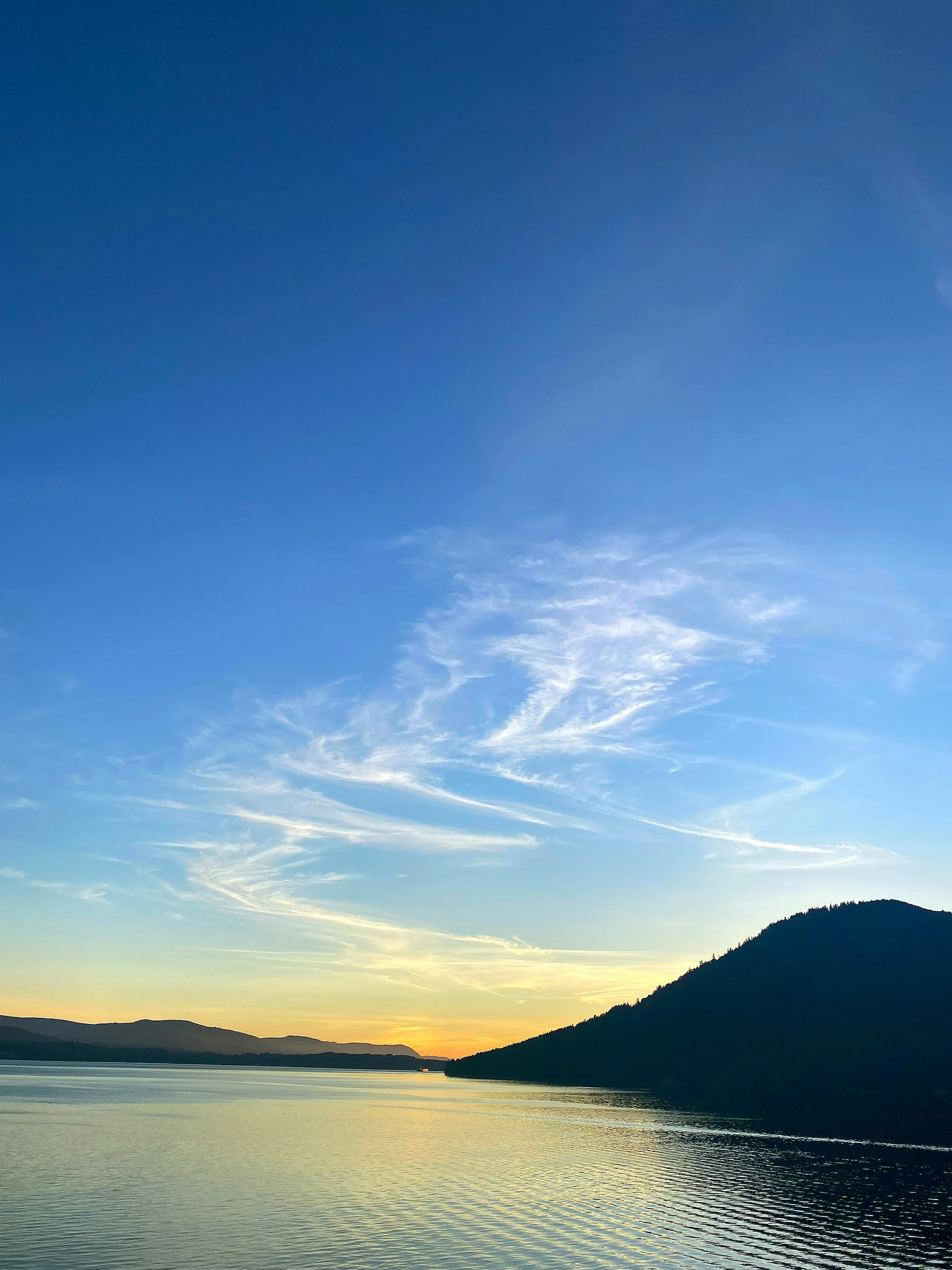 Ruhige Seesicht mit blauem Himmel und zarten Wolken