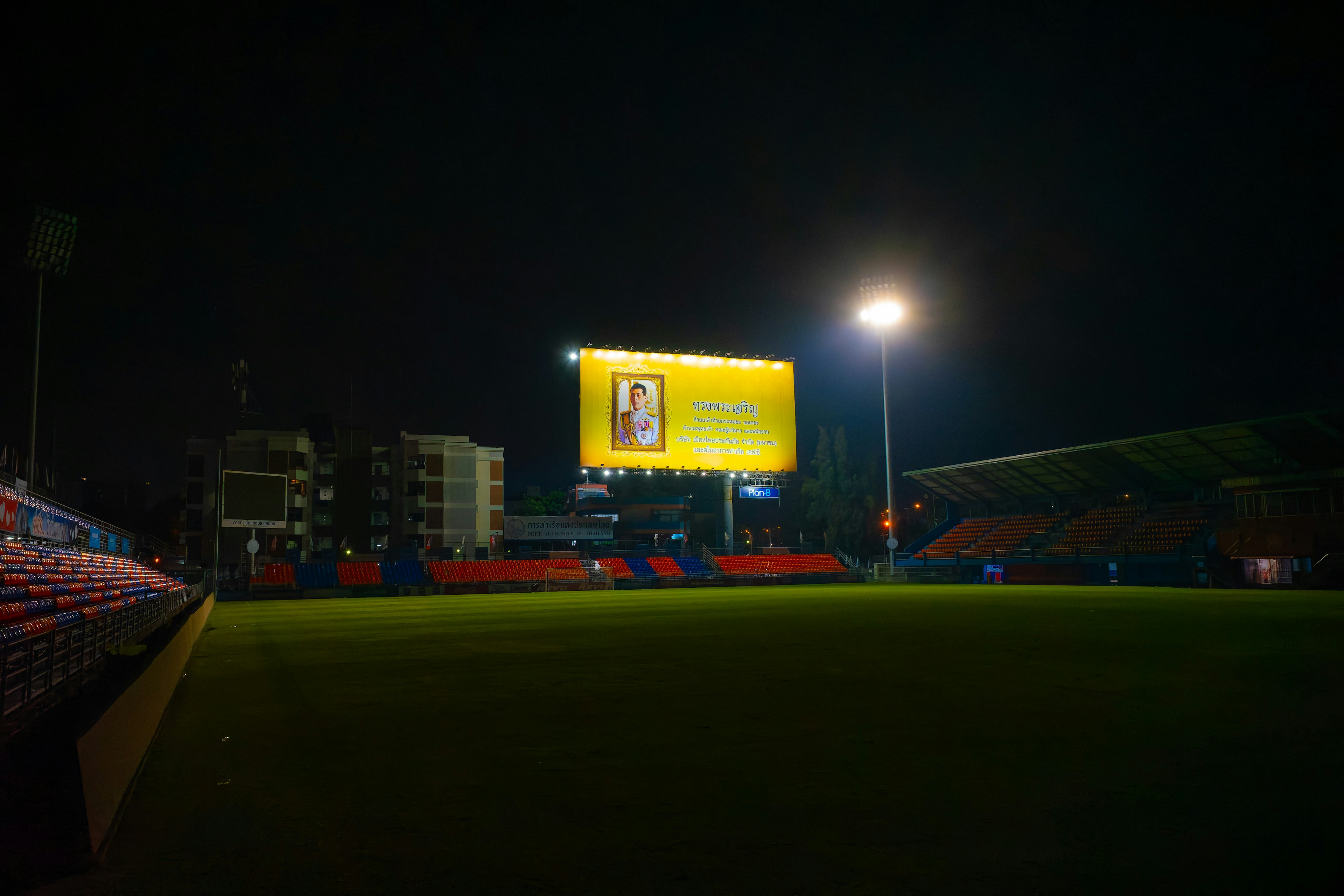 Papan iklan cerah dan lampu stadion di malam hari