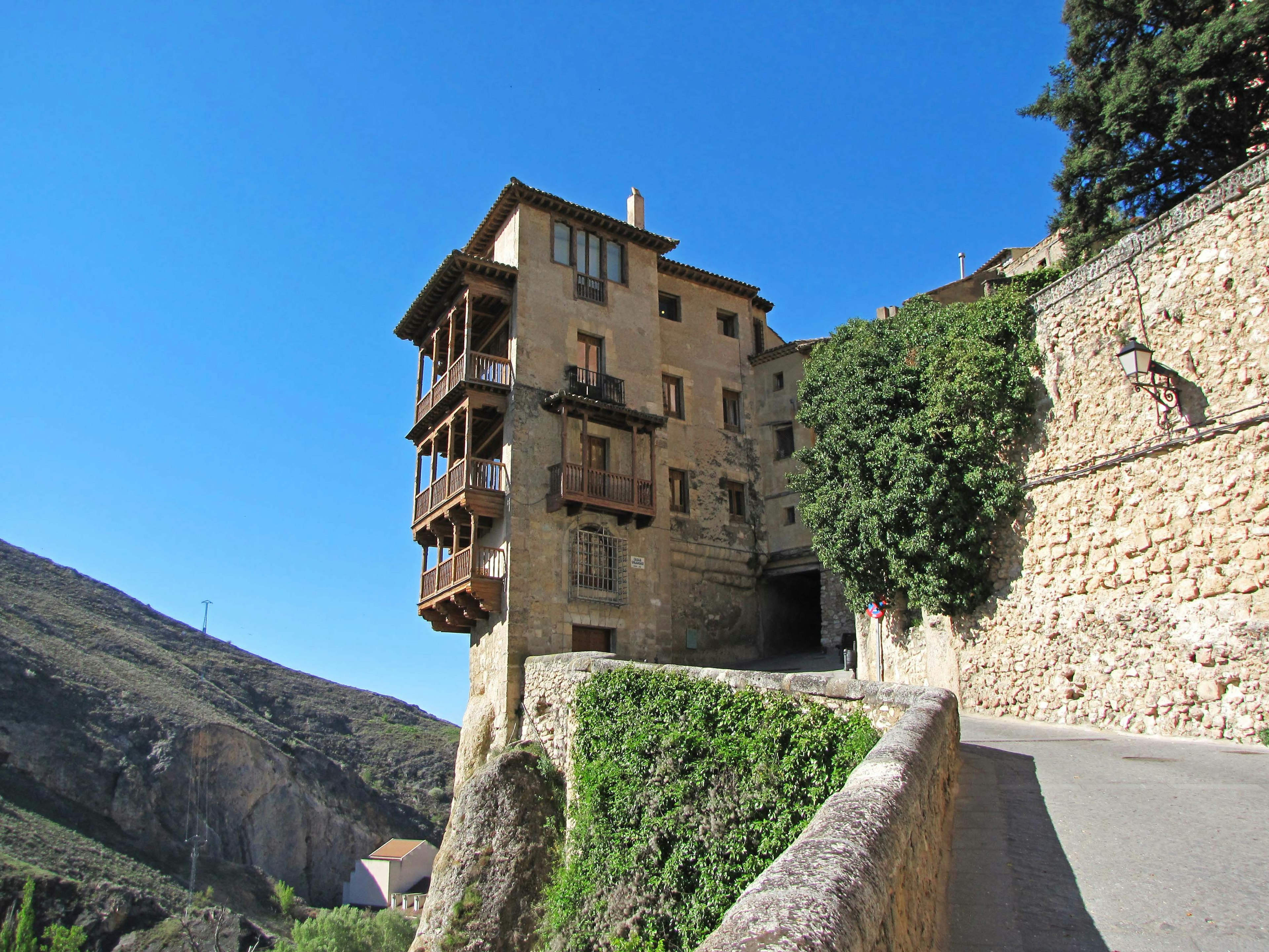 Unique building perched on a mountainside featuring traditional design and balconies