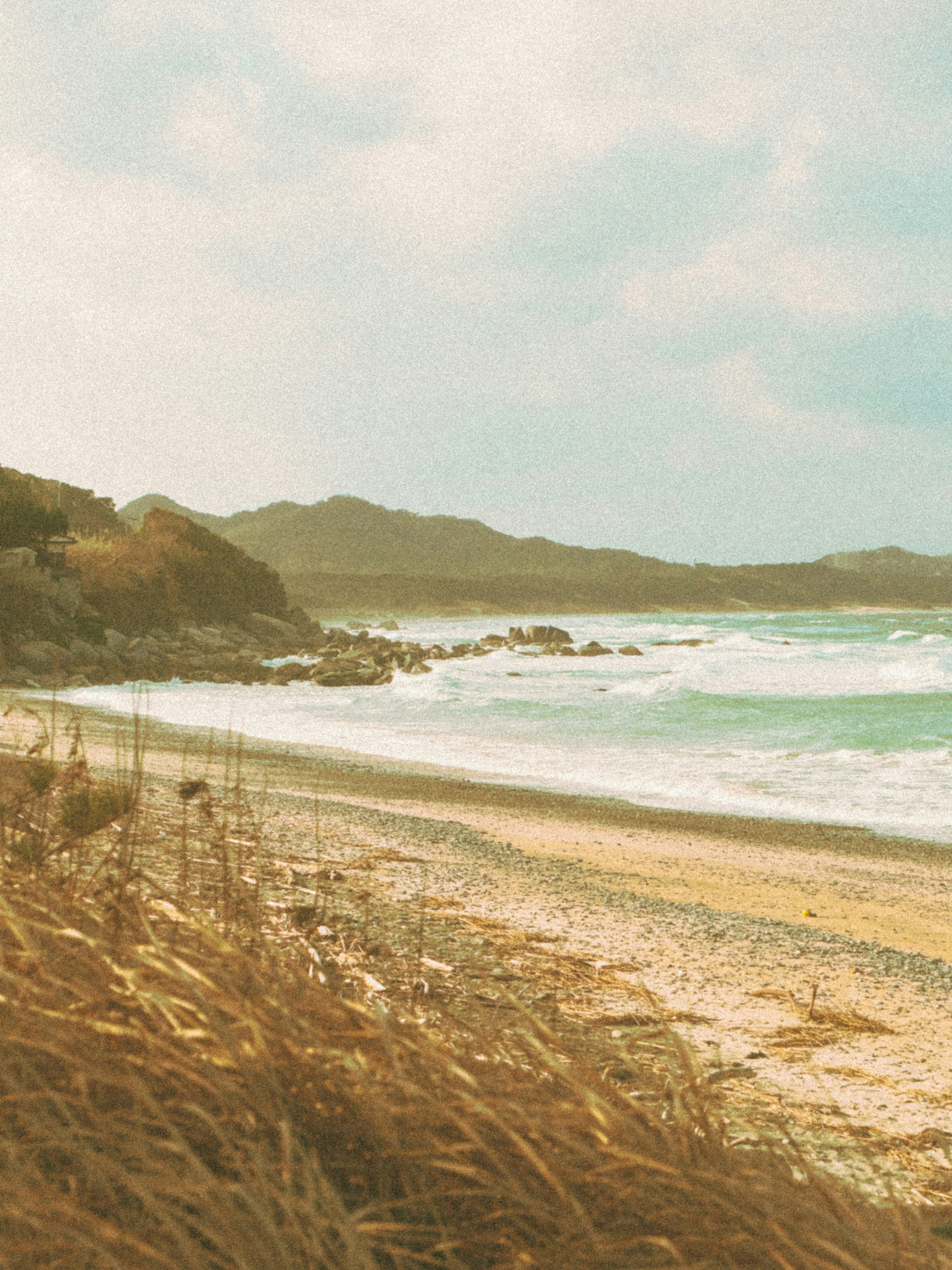 Paisaje de playa sereno con orilla de arena y olas al fondo