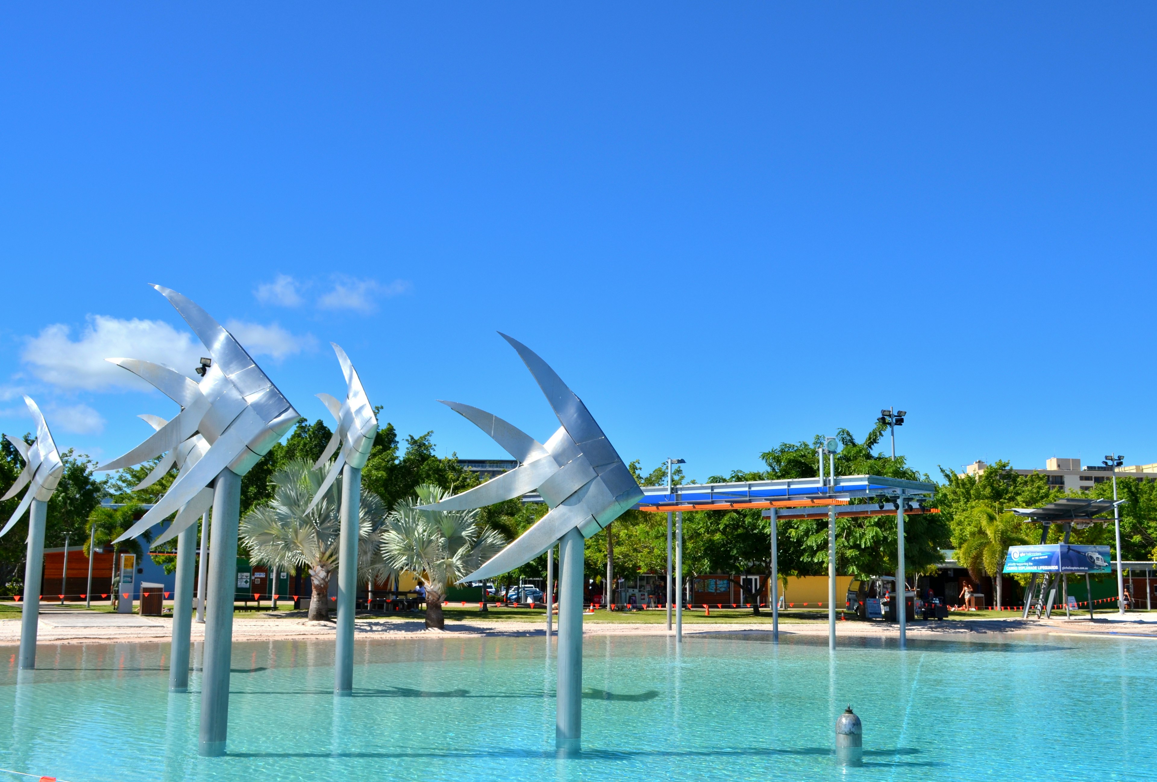 Modern wind sculpture in a water feature under a blue sky