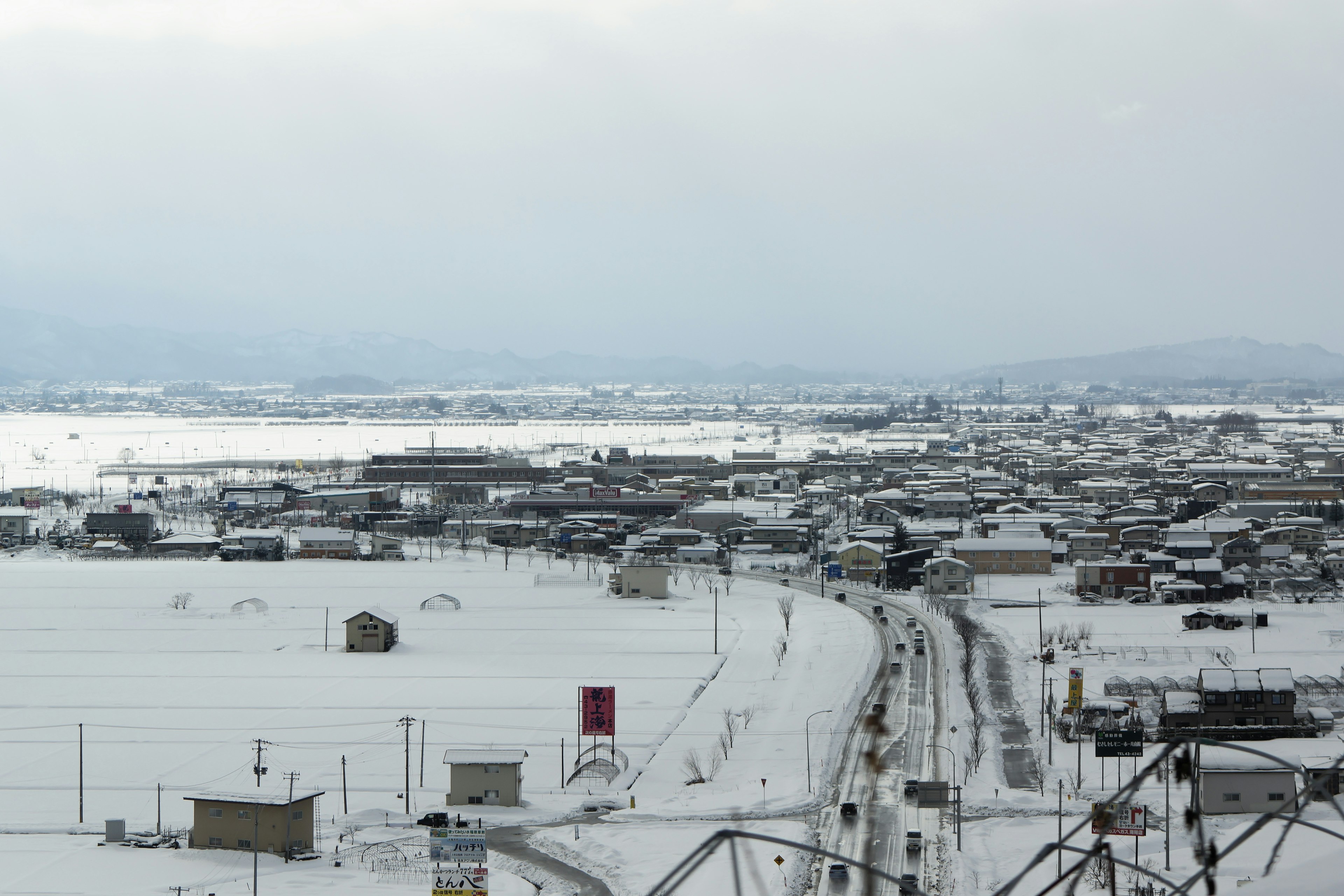 Snow-covered landscape of a town with a winding road