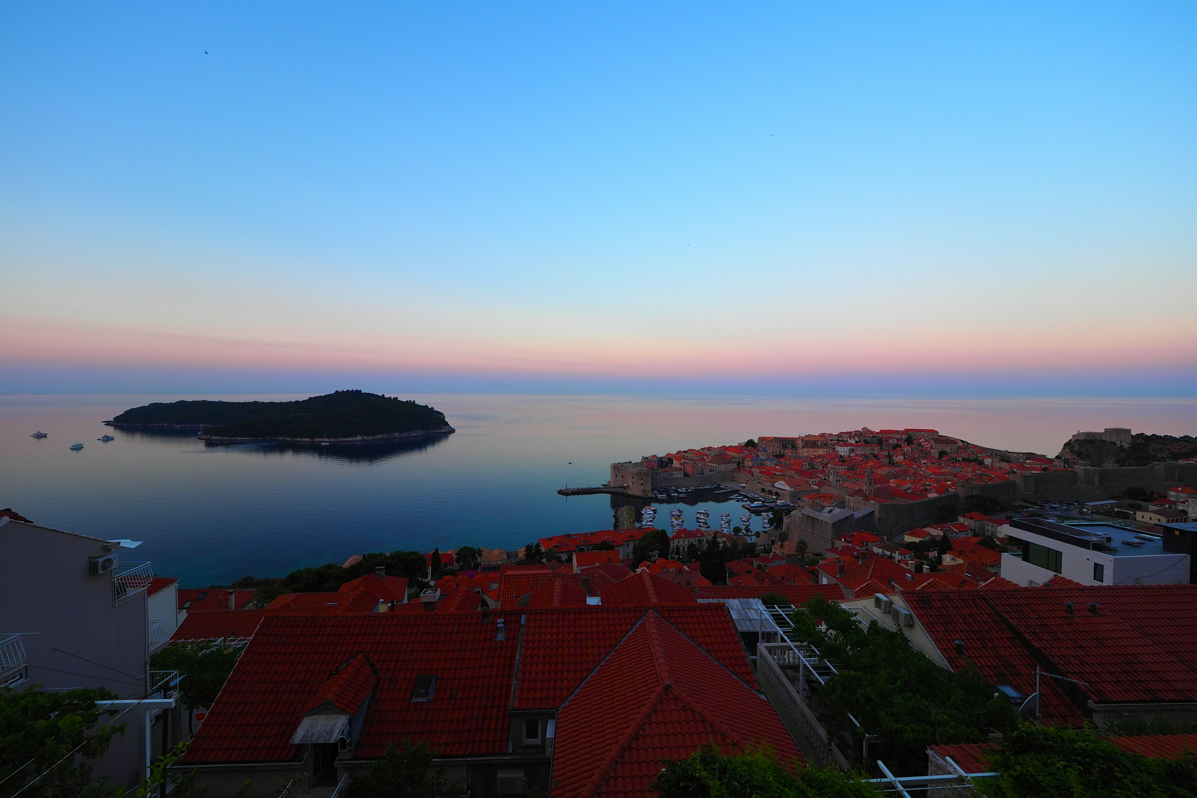 Schöner Sonnenuntergang über dem Meer mit roten Dächern