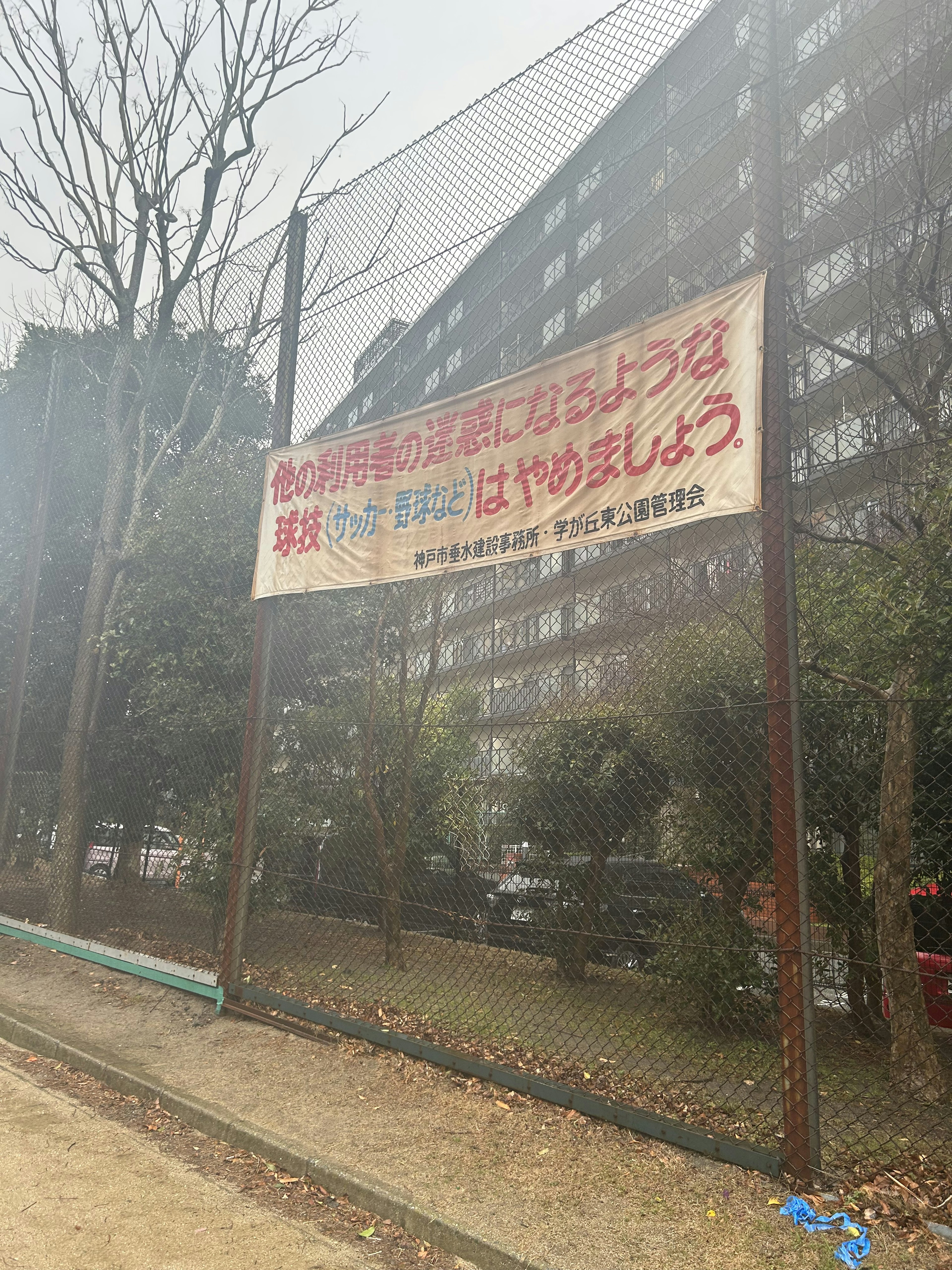 Großes Schild vor einem Wohngebäude an einem bewölkten Tag