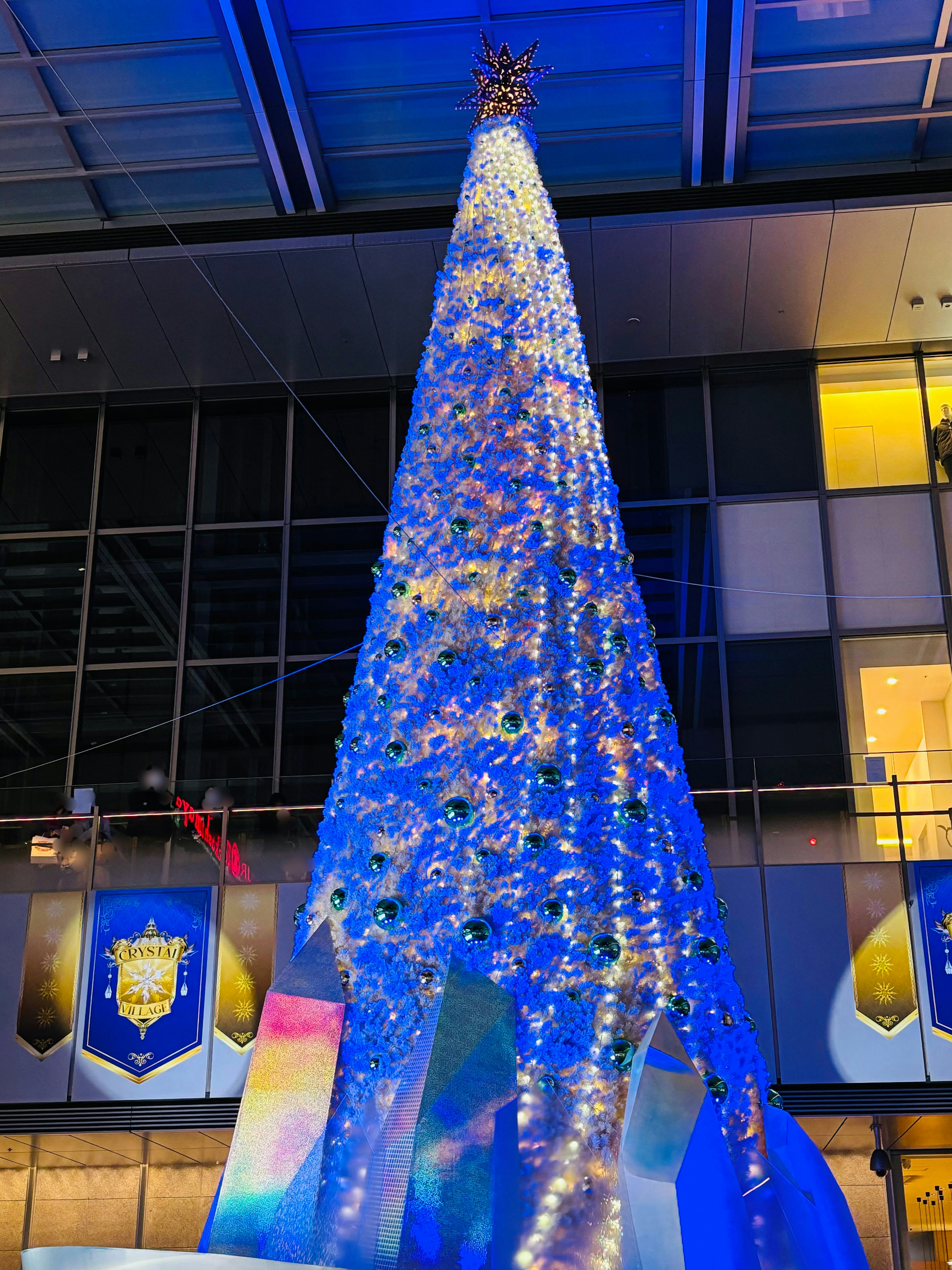 Un alto árbol de Navidad iluminado con luces azules