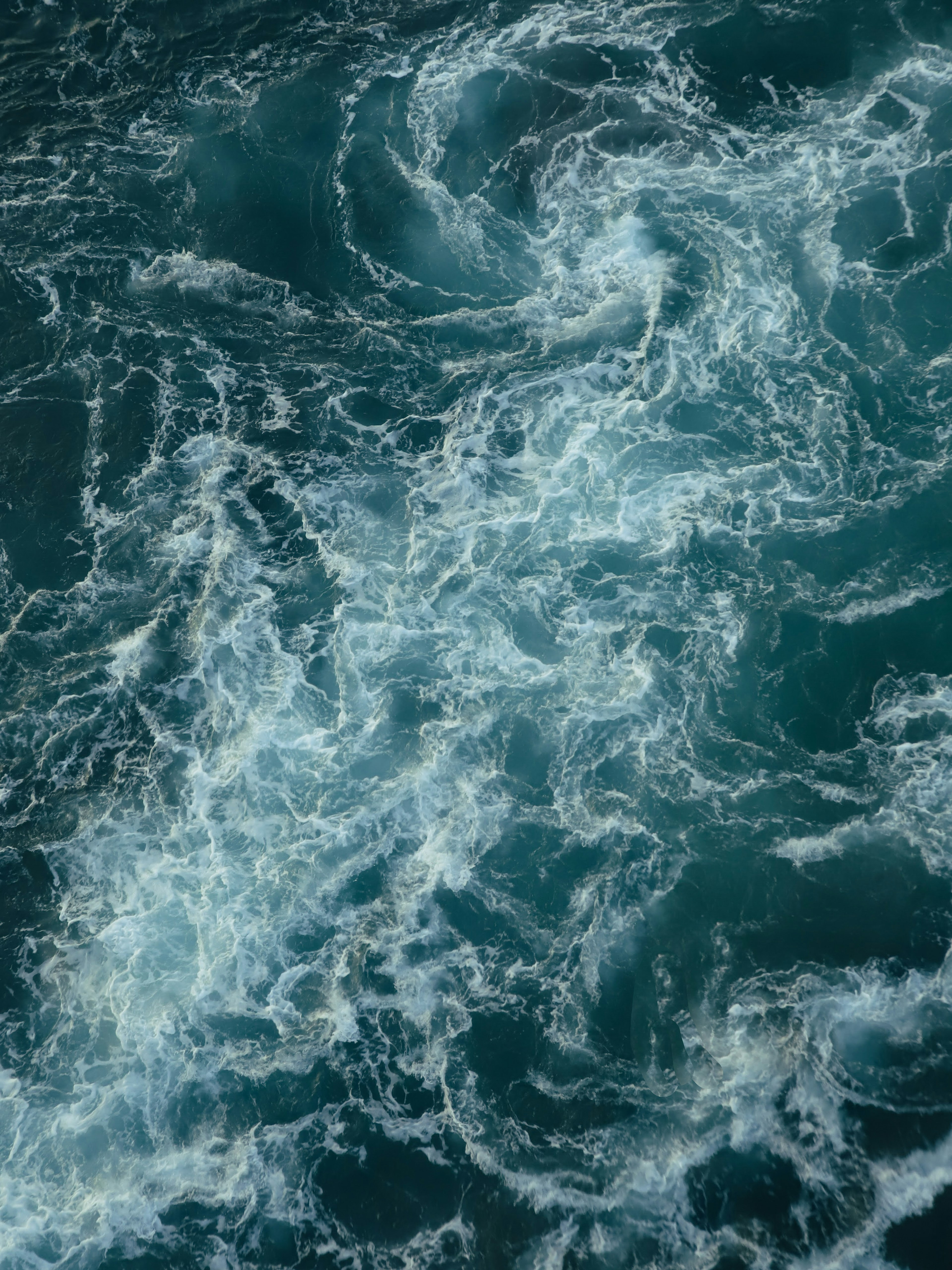 Imagen de agua de océano azul con patrones de espuma blanca