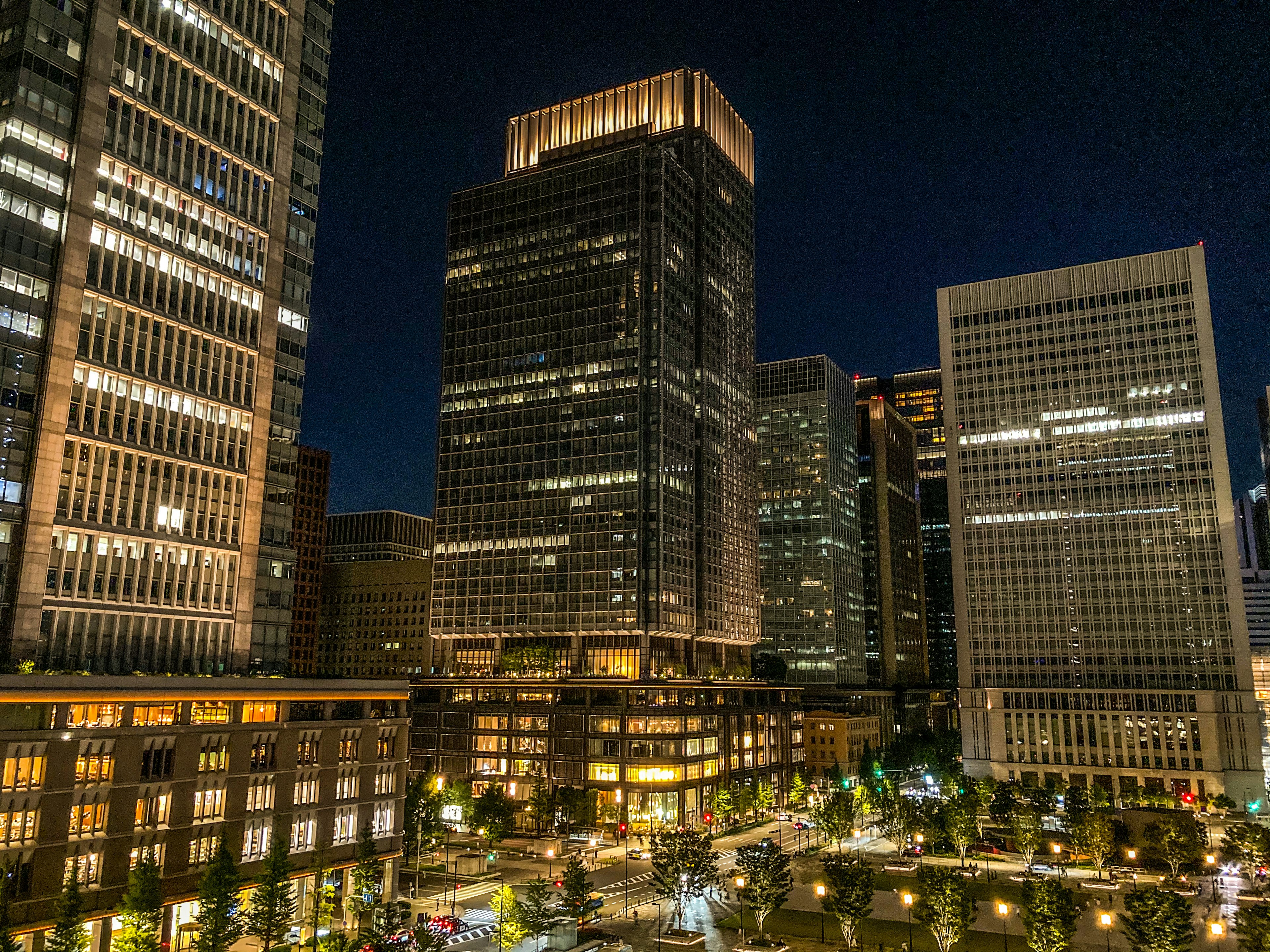 Stadtansicht bei Nacht mit beleuchteten Gebäuden und Park