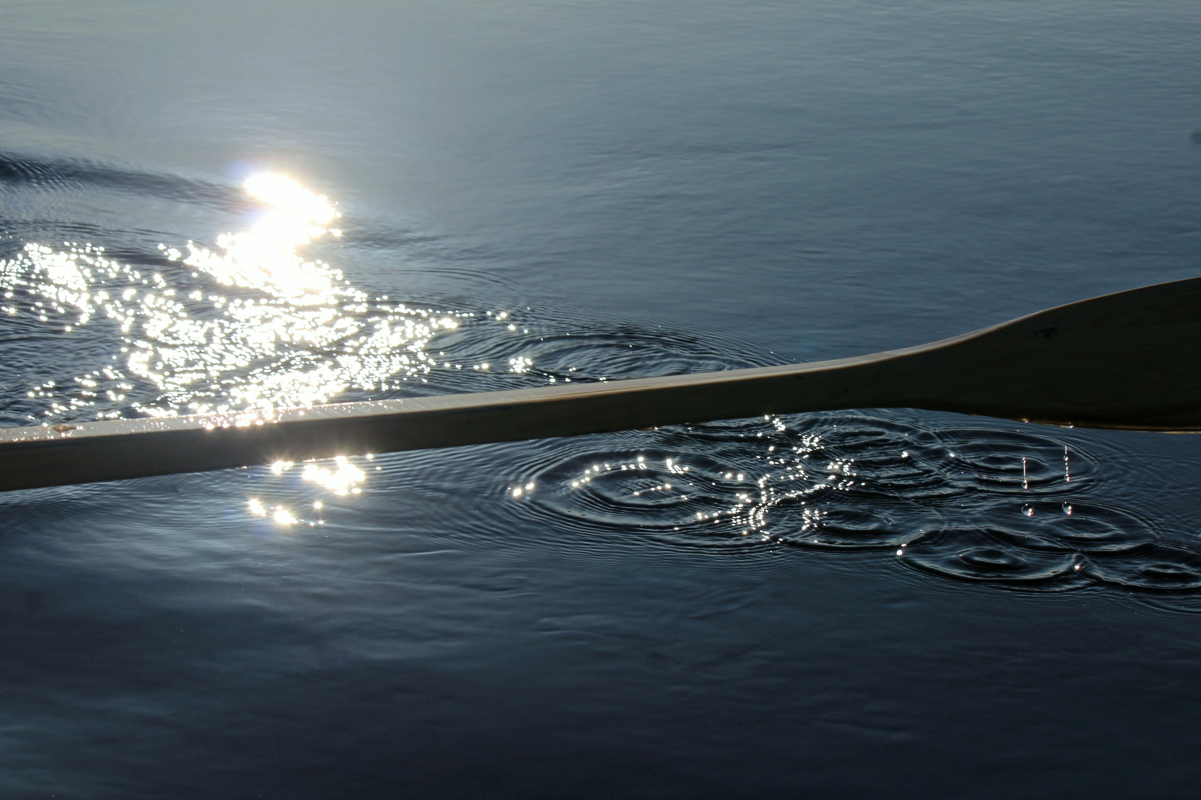 Reflections of light on the water surface with a paddle