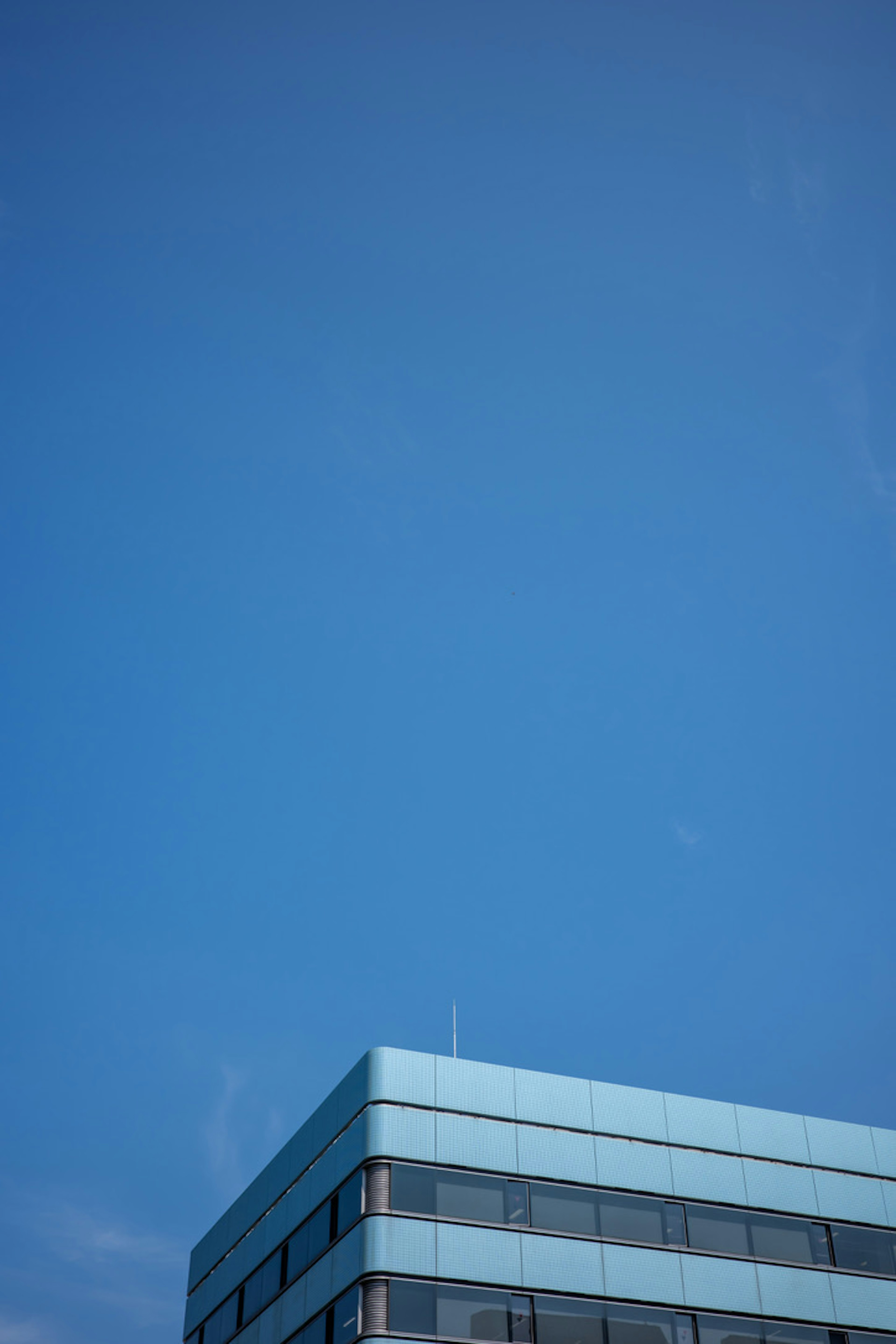 Top part of a modern building against a clear blue sky