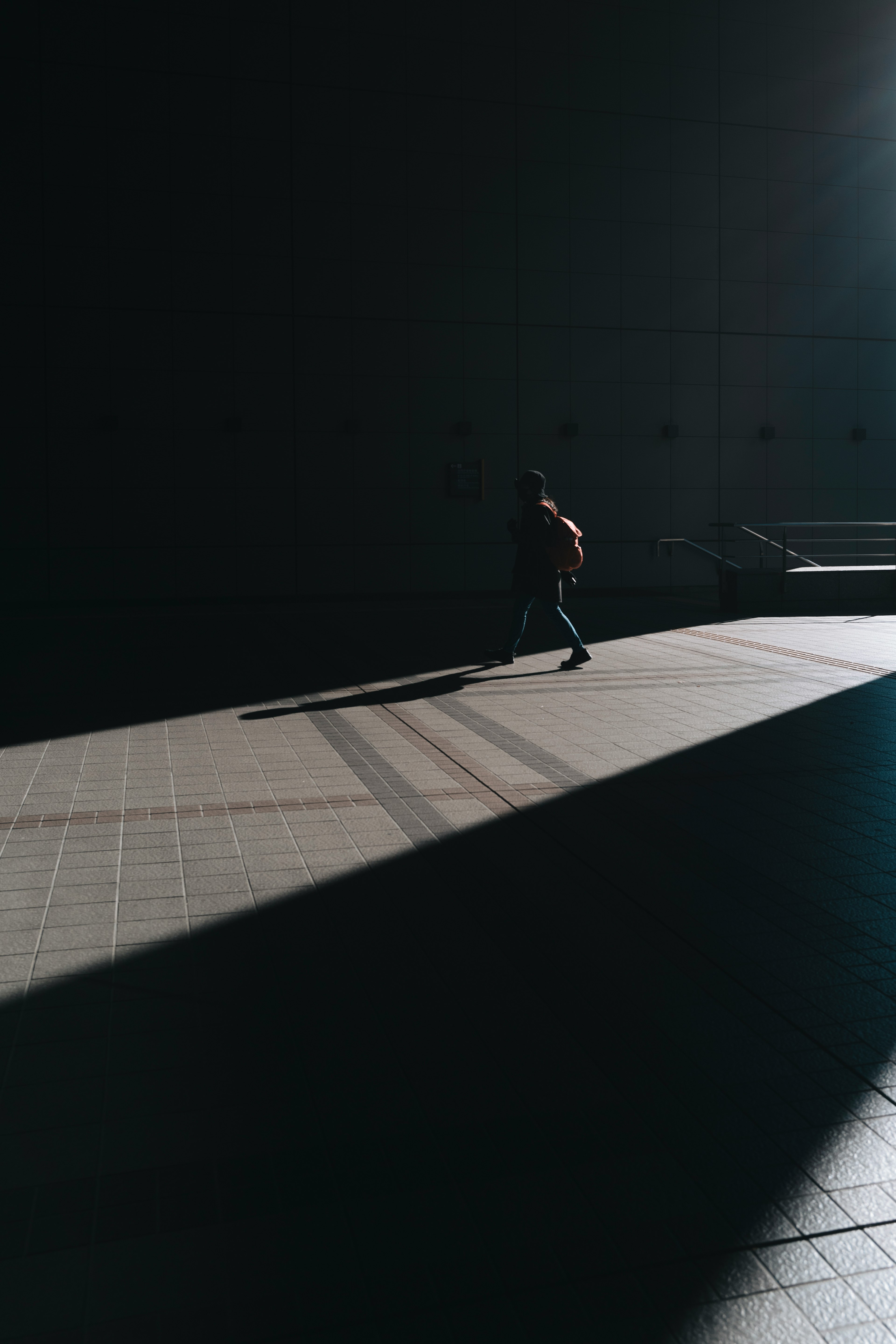 Silhouette of a person walking in shadow with strong contrast in the scene