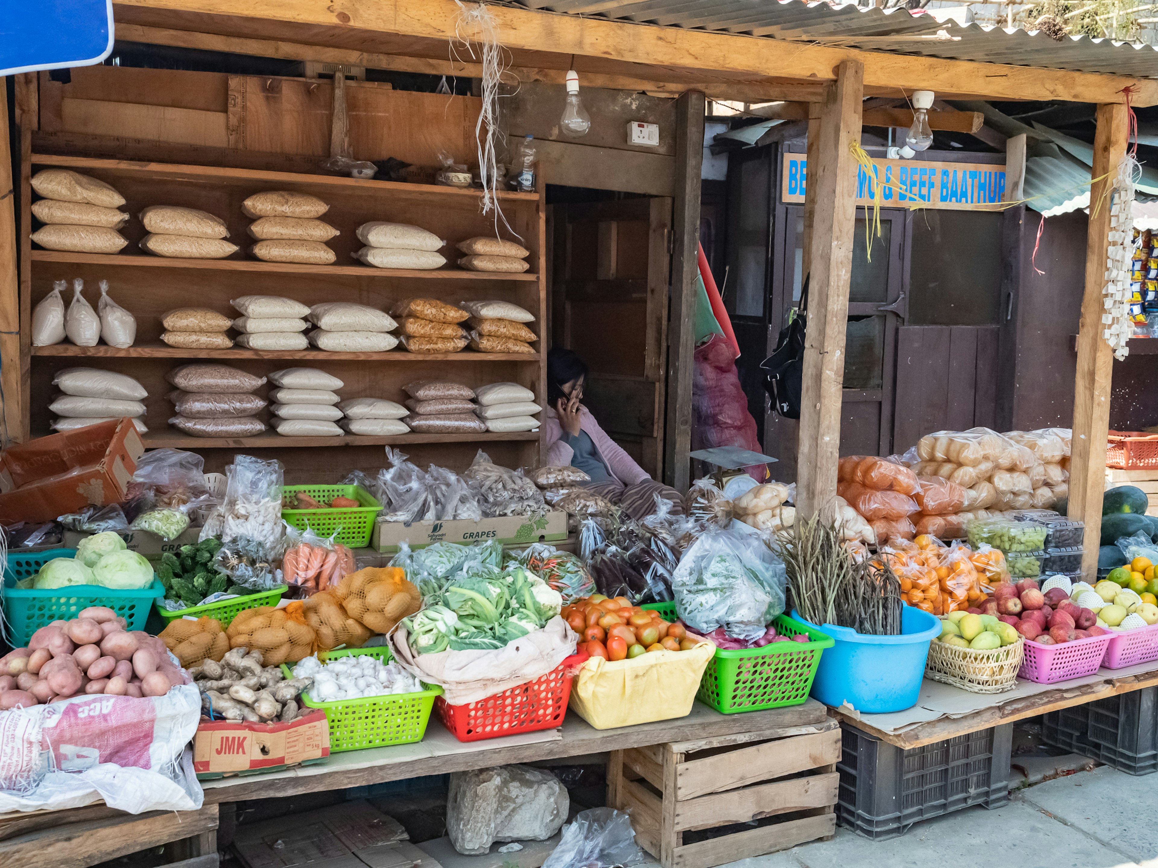 Sebuah kios pasar yang menampilkan berbagai sayuran dan buah segar