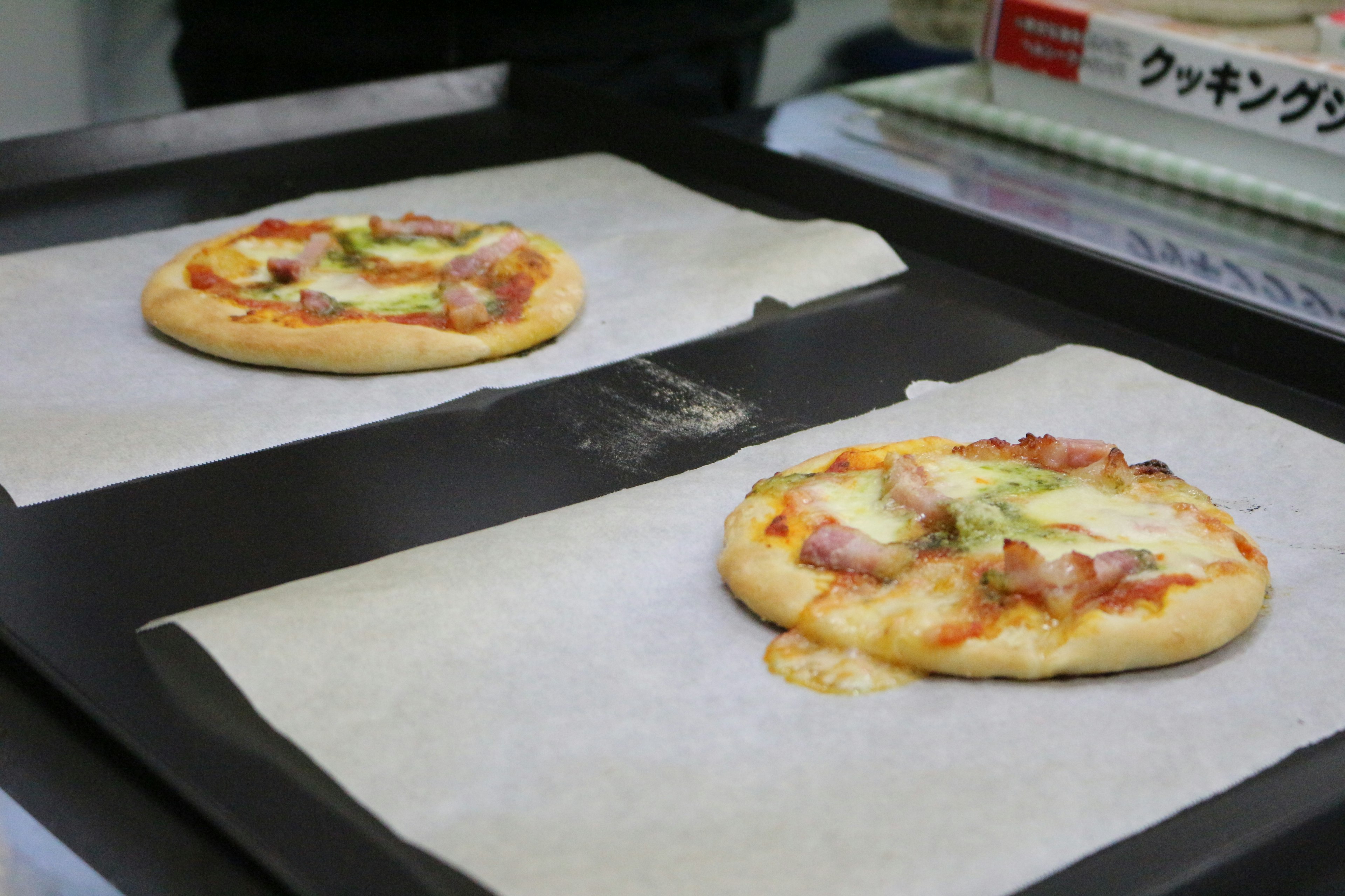 Dos mini pizzas colocadas sobre papel de hornear