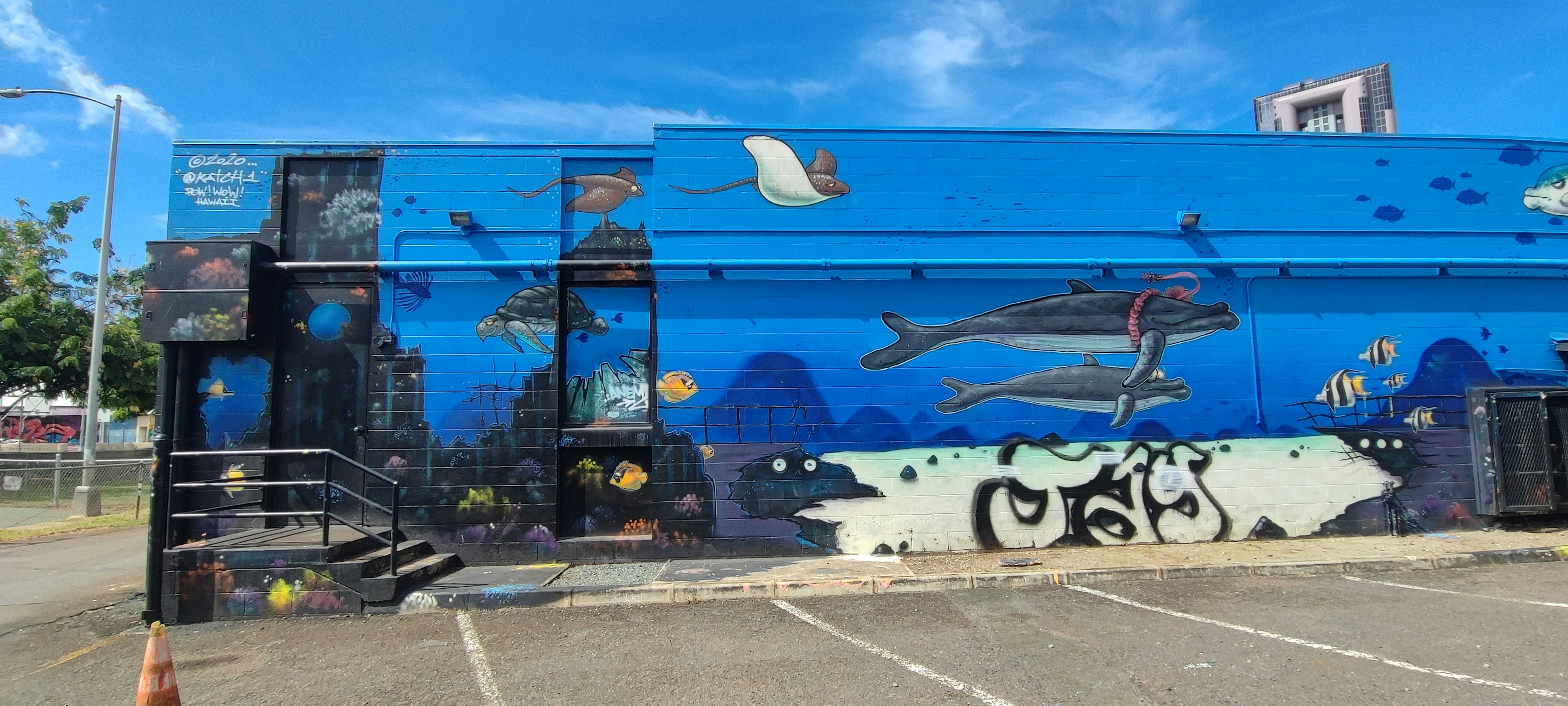 Mural azul vibrante que representa criaturas marinas, incluidos delfines y peces nadando