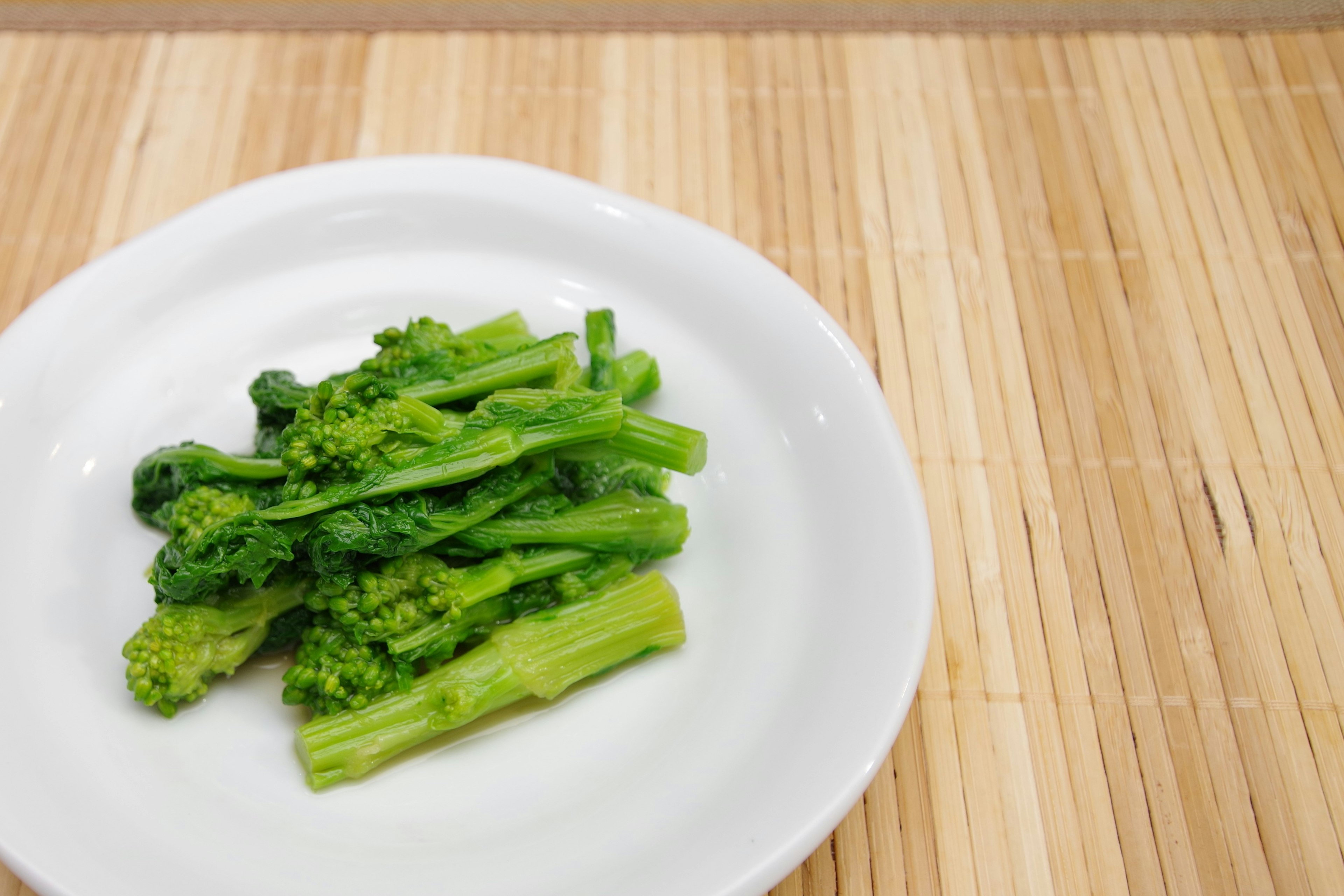 Broccolini segar disajikan di piring putih