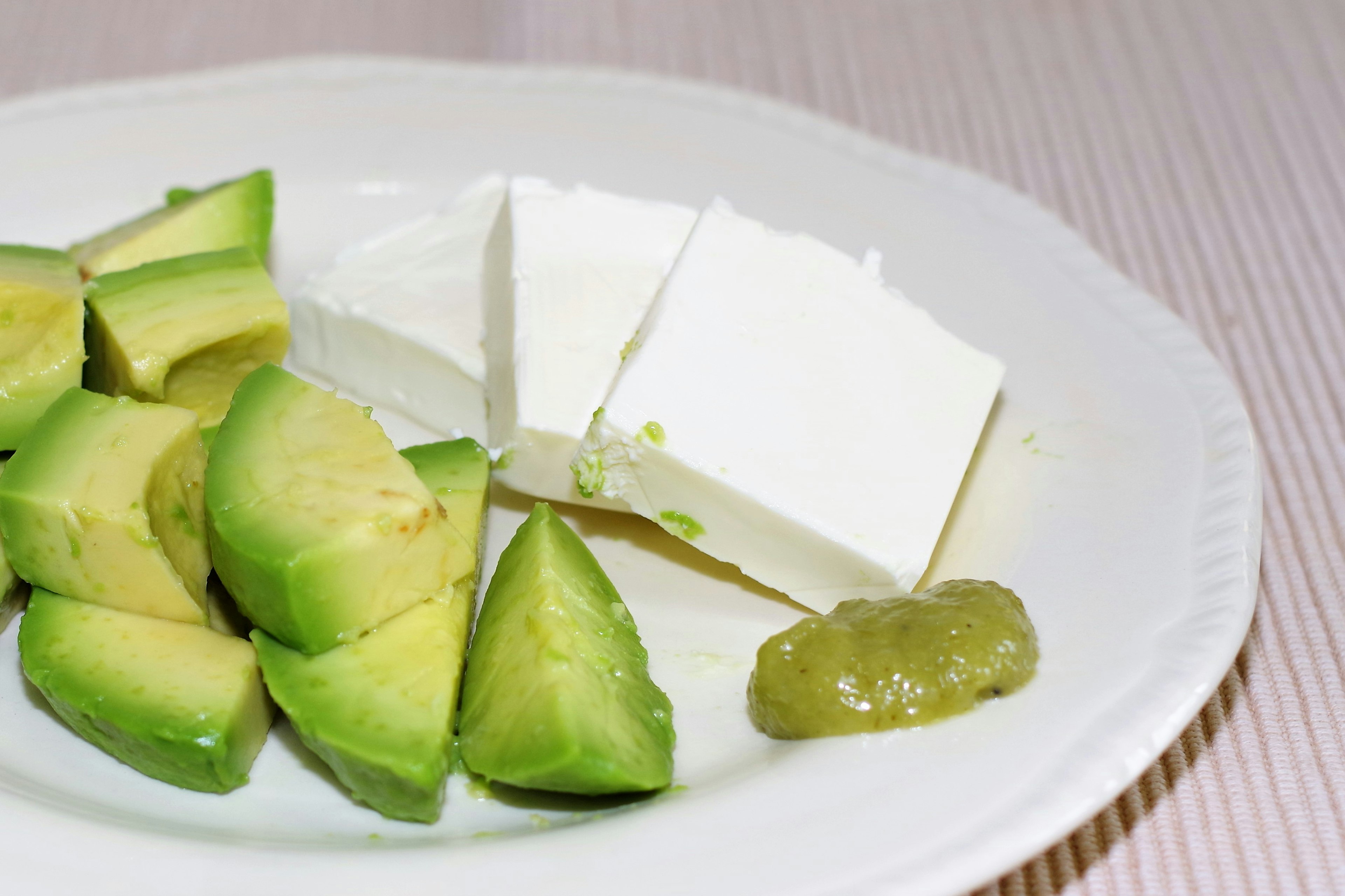 Sliced avocado and blocks of tofu on a plate