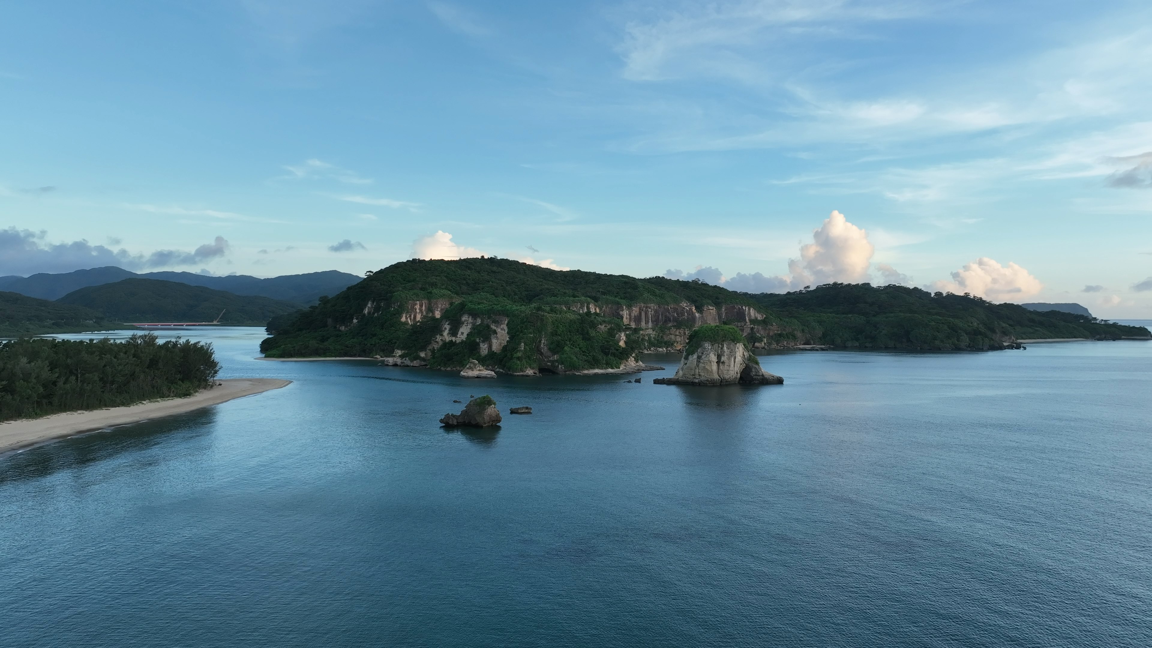 Pemandangan indah sebuah pulau dikelilingi oleh air dan langit biru