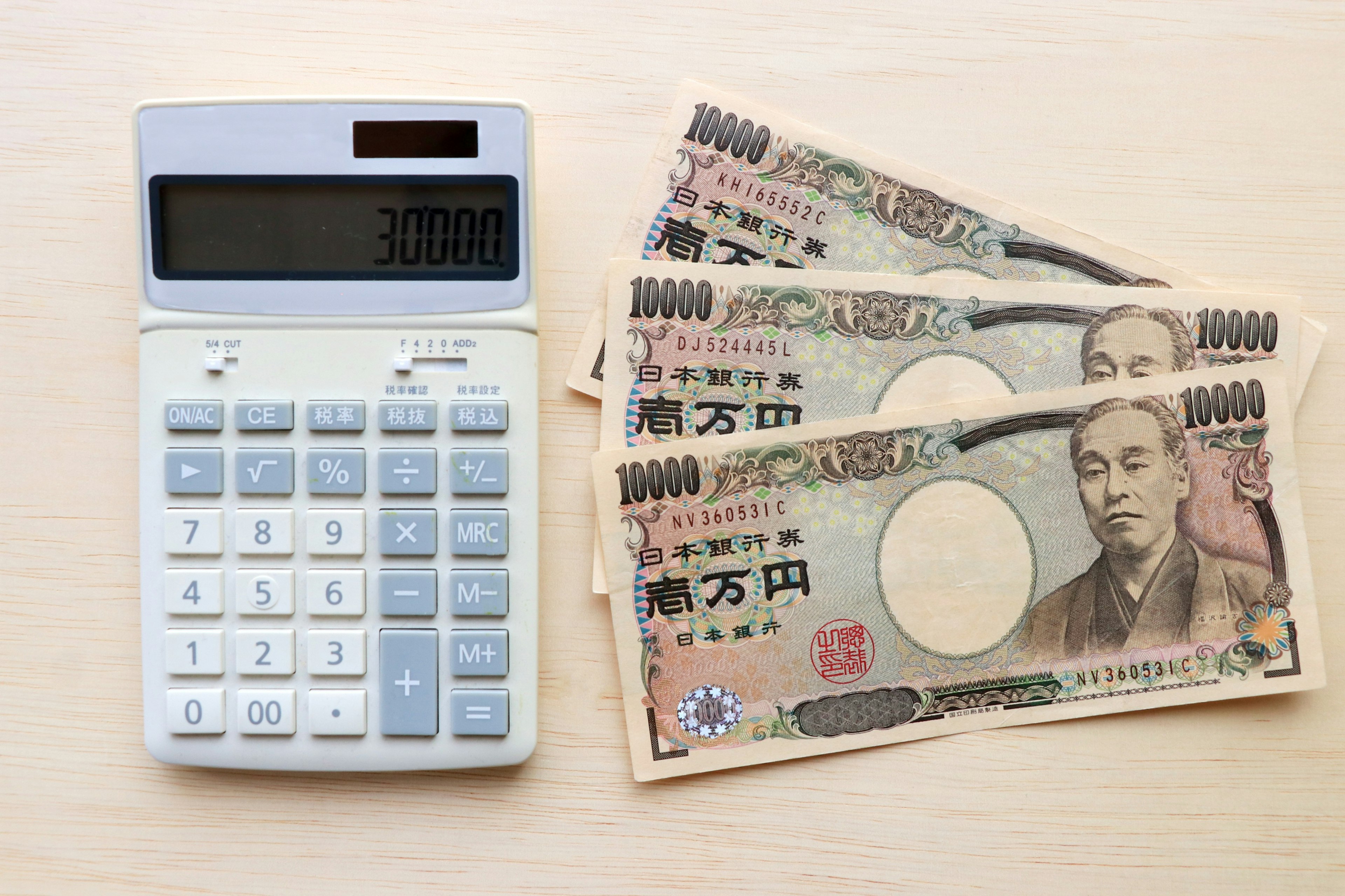 Calculator and Japanese yen banknotes arranged on a surface