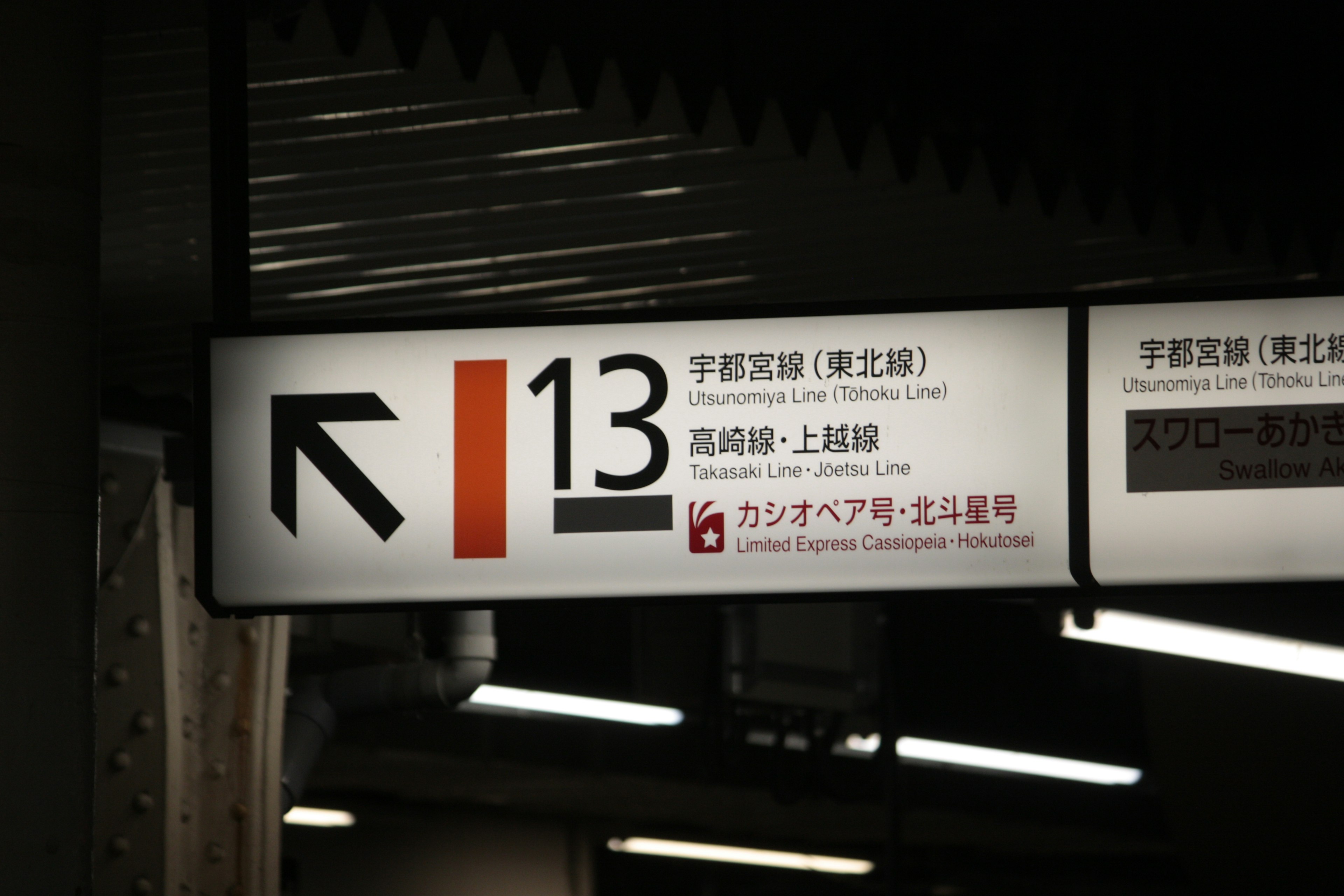 Signage at a train station featuring a left arrow and number 13