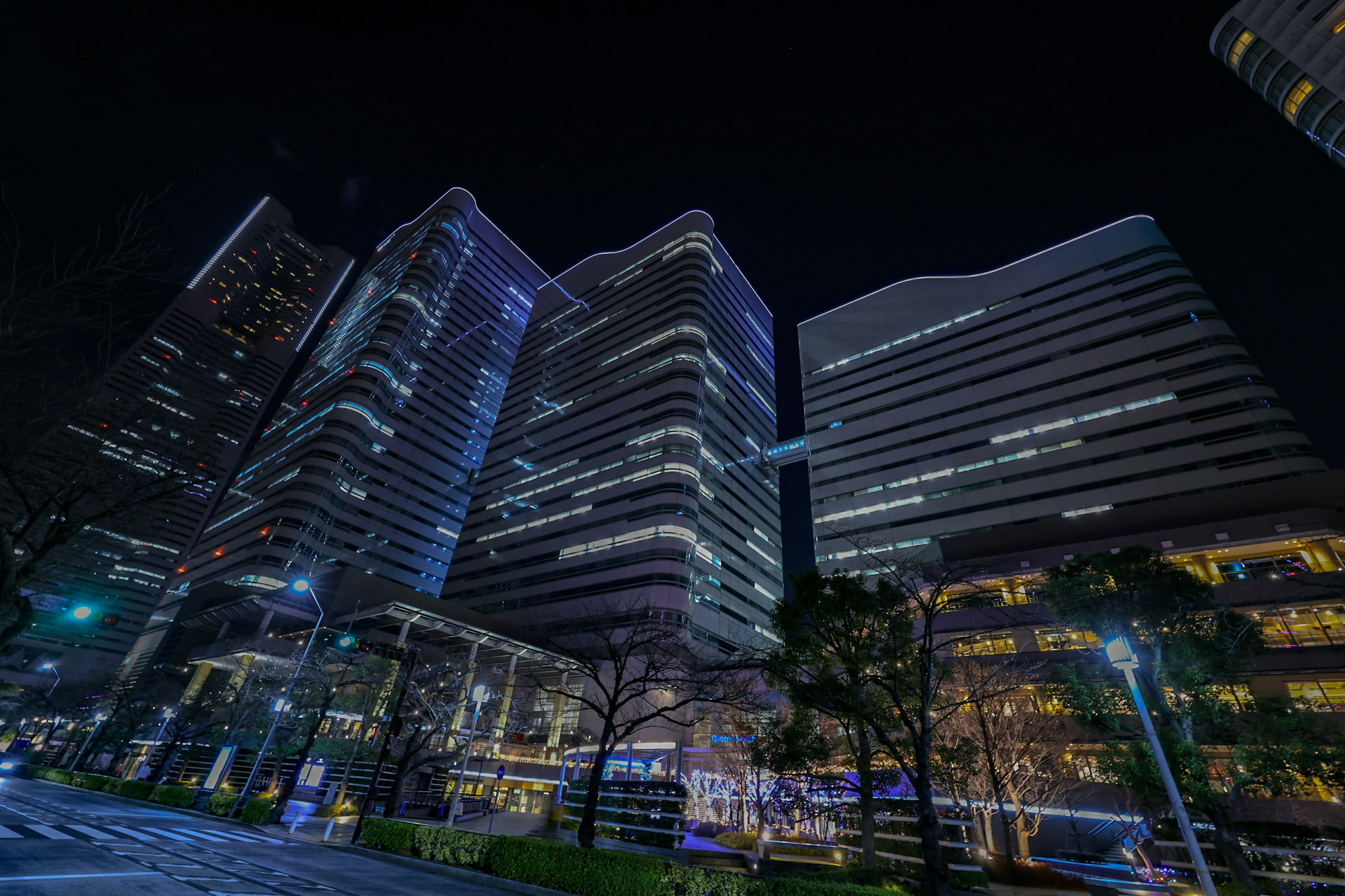 Paisaje urbano nocturno con rascacielos iluminados que muestran una arquitectura moderna