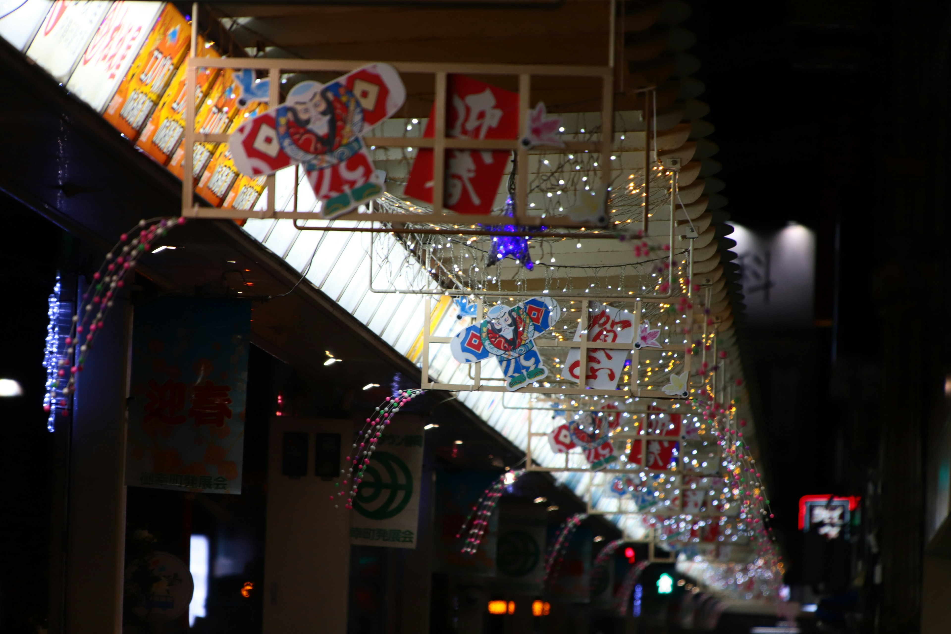 Arcada decorada en una calle comercial por la noche con letreros brillantes