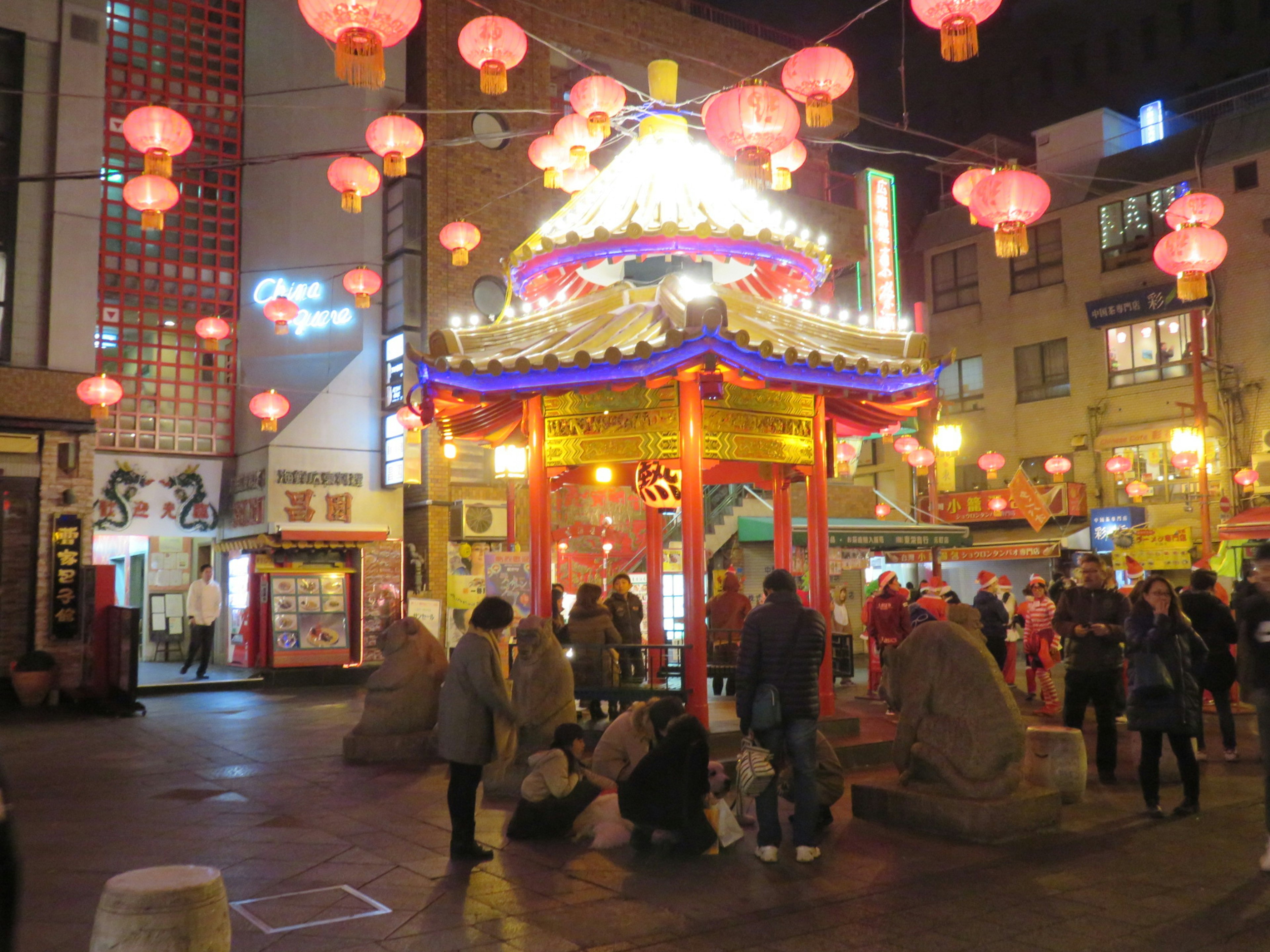 華やかな提灯が飾られた夜の街角で人々が集まる光景